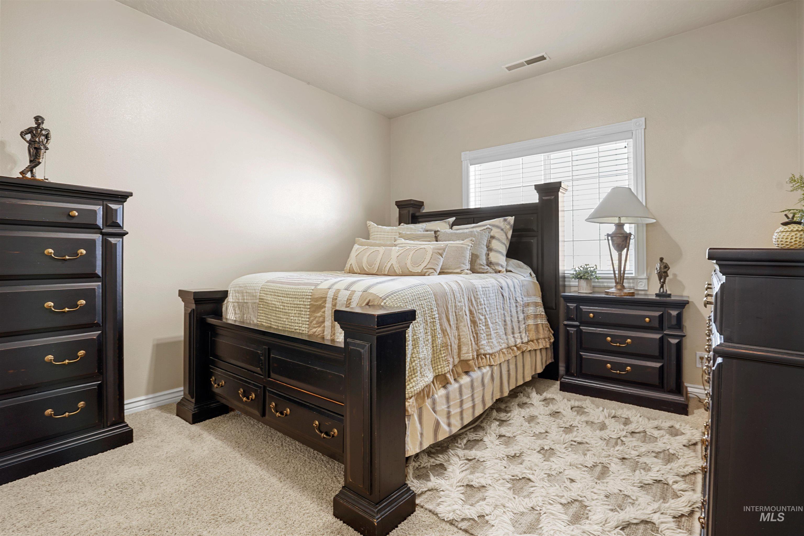 Bedroom with light carpet and baseboards