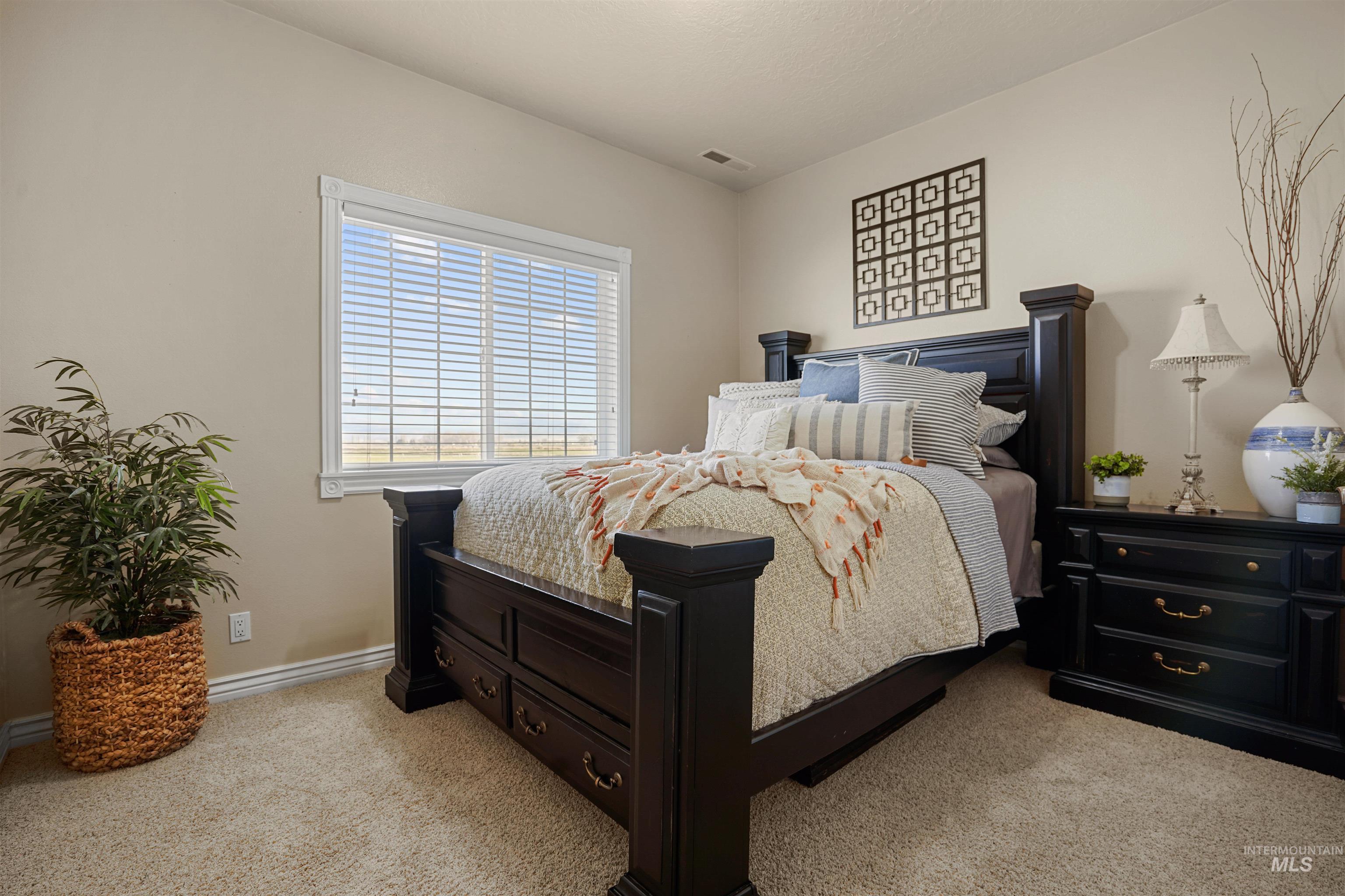 Bedroom featuring light carpet and baseboards