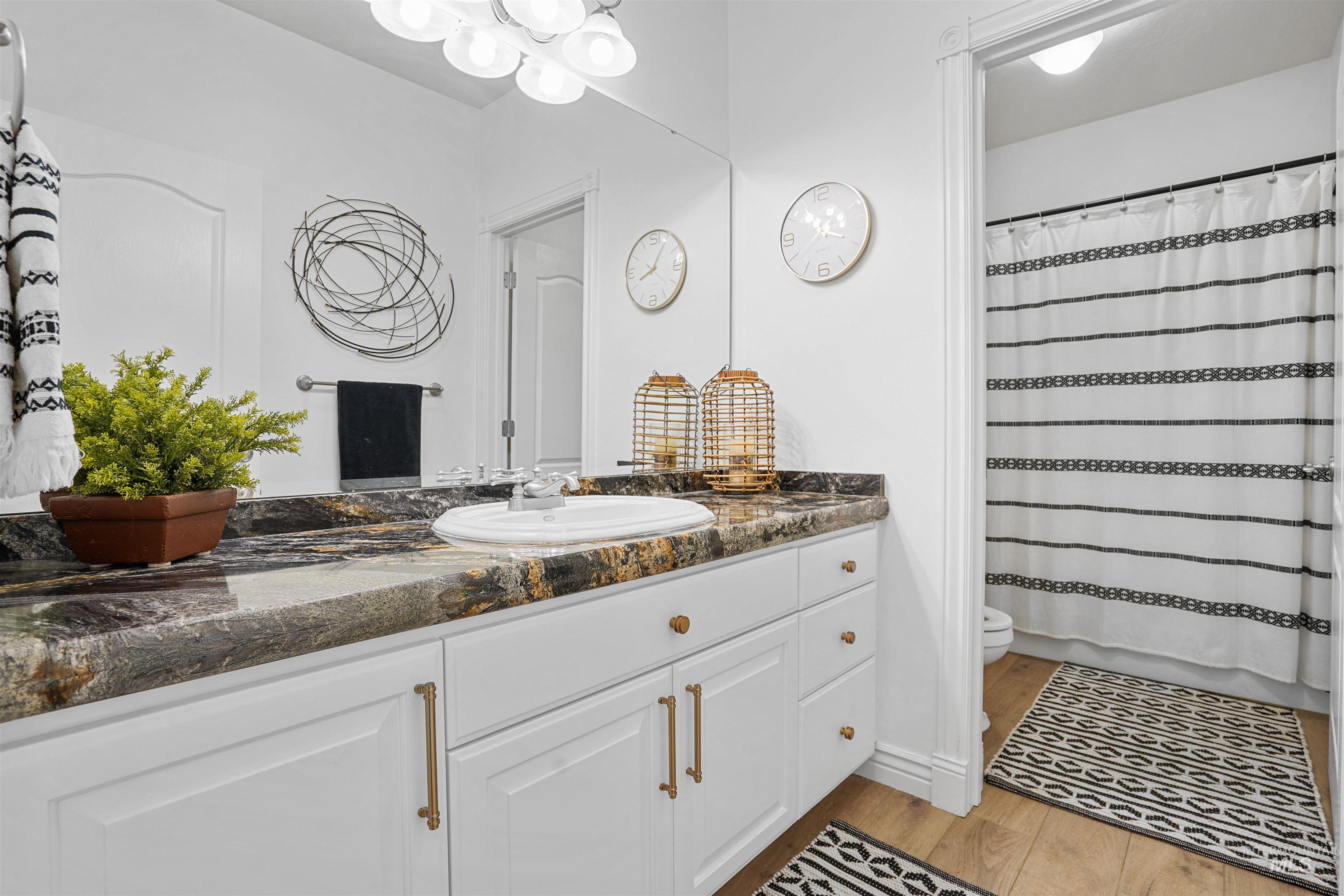 Bathroom with a shower with curtain, vanity, and light wood-style floors