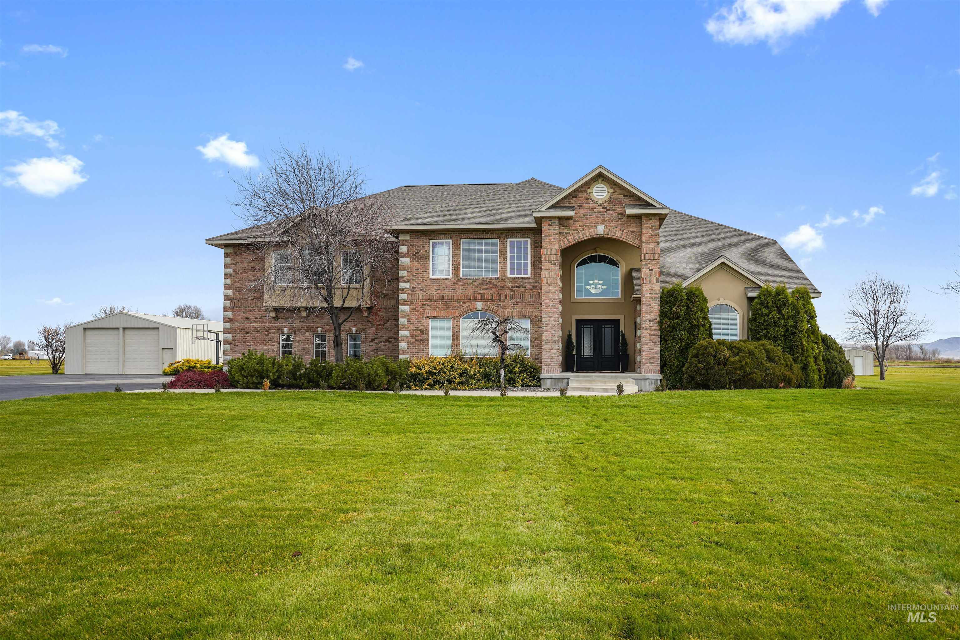 View of front of property featuring a front yard, brick siding, and a shingled roof