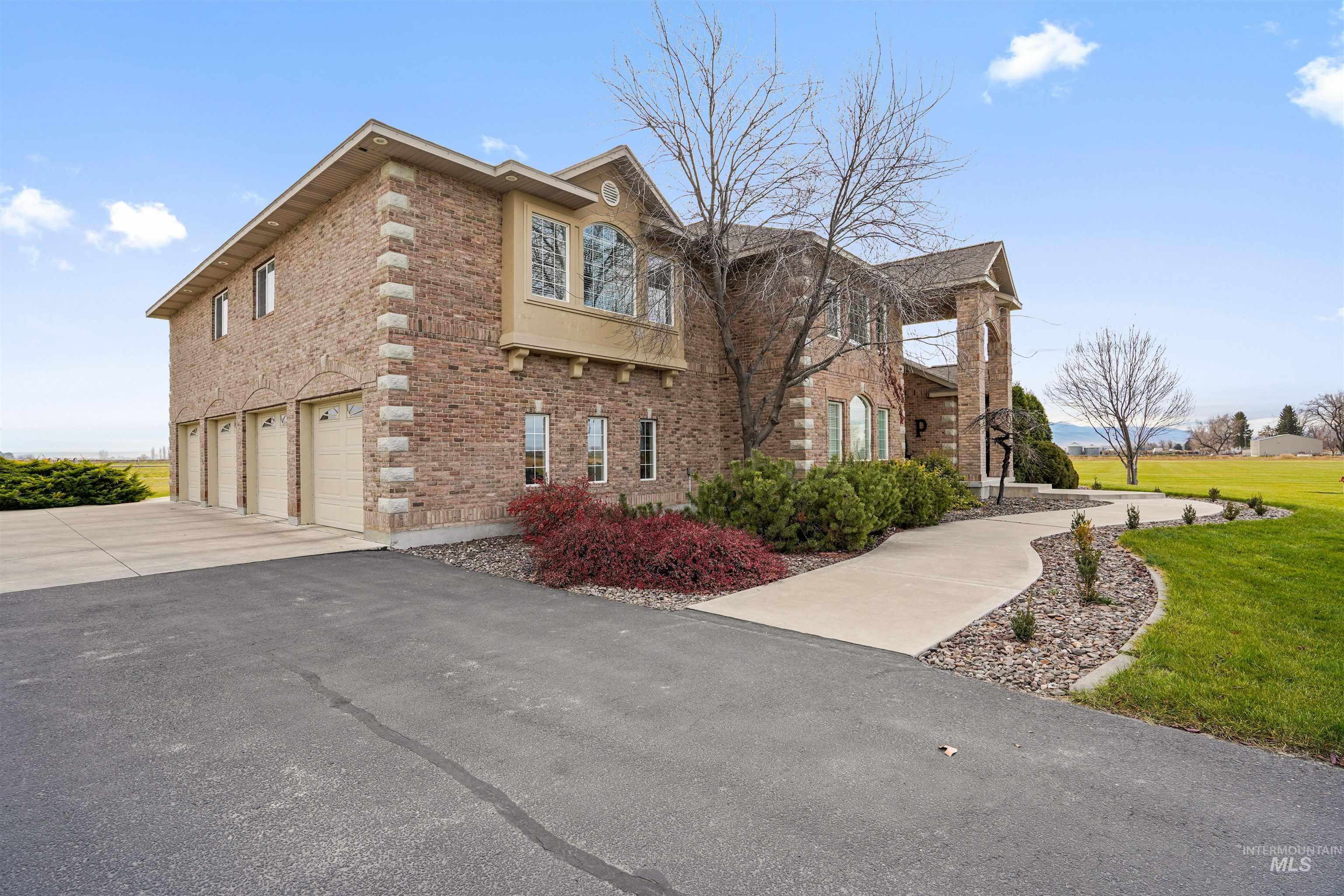 View of home's exterior featuring brick siding, an attached garage, driveway, and a lawn