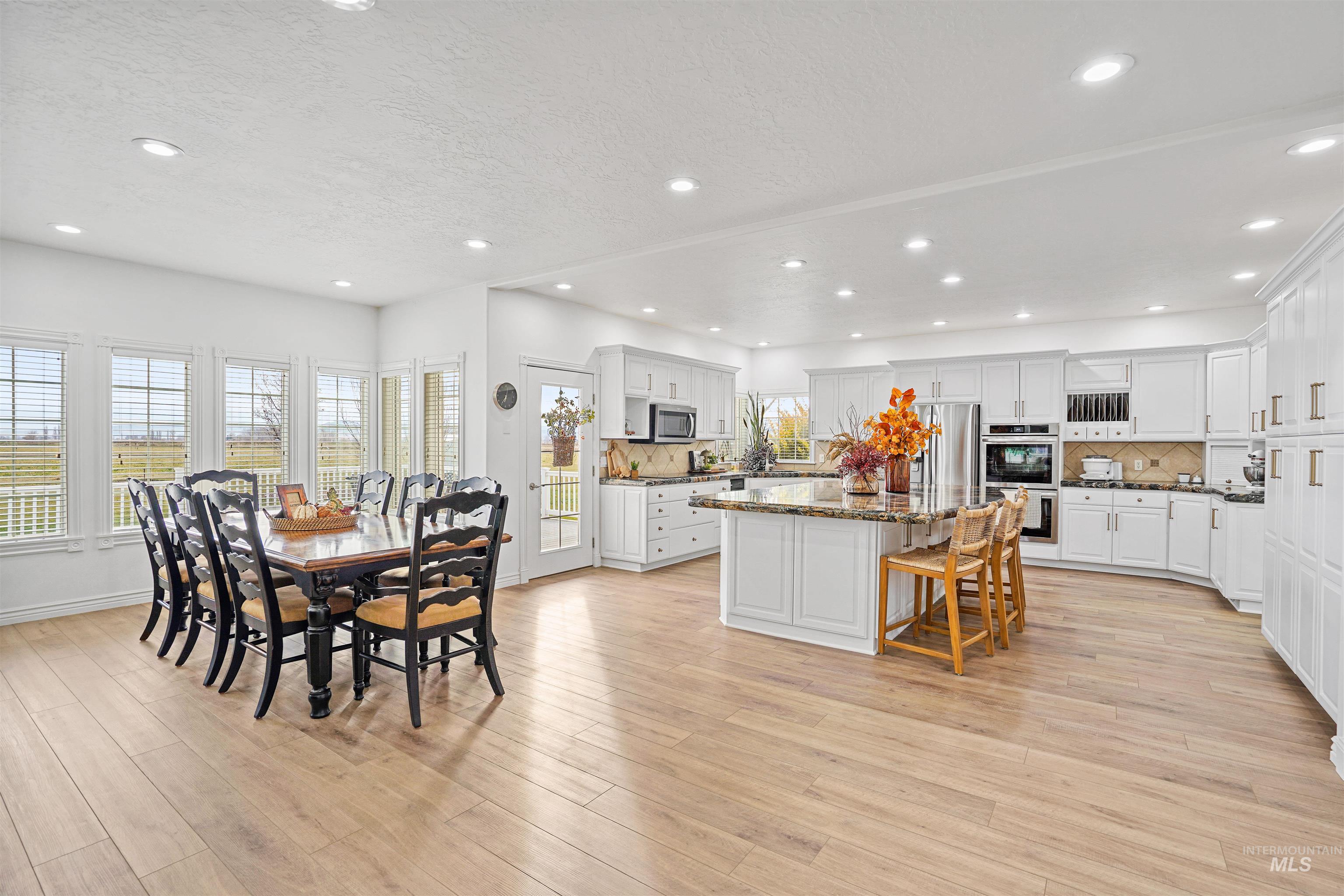 Dining area with light wood-style floors, recessed lighting, and a textured ceiling