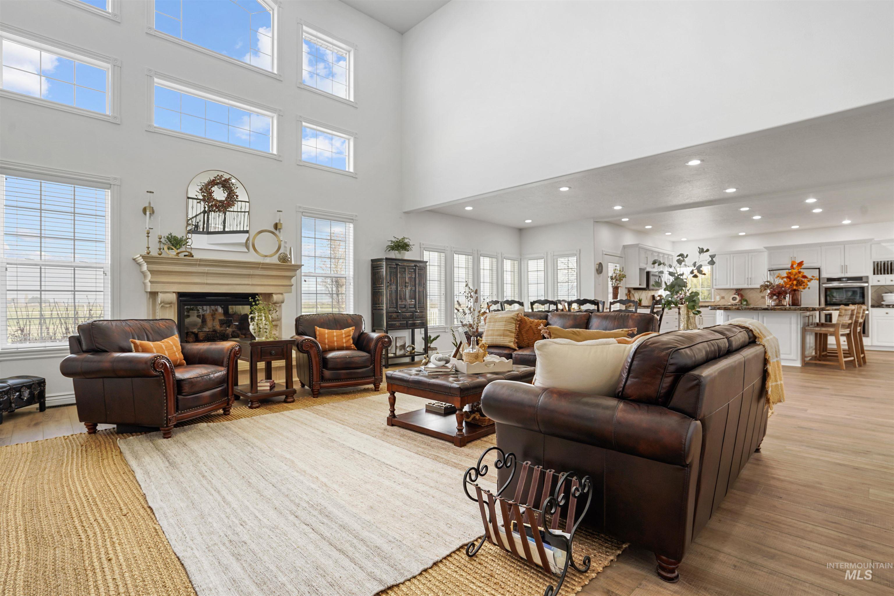 Living area with light wood-style floors, a glass covered fireplace, and recessed lighting