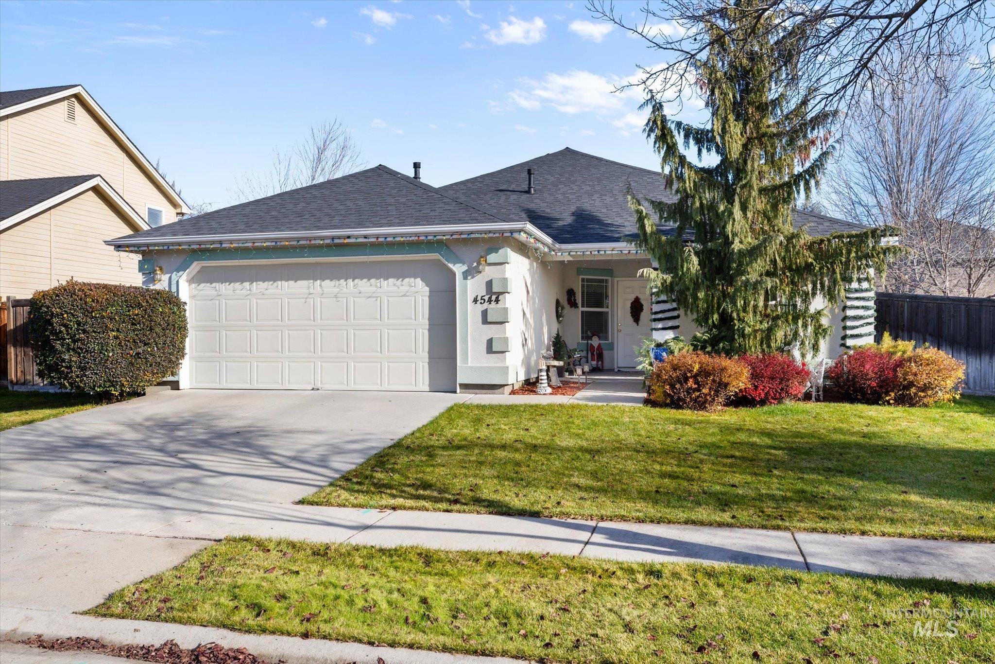 View of front of property with a shingled roof, an attached garage, a porch, concrete driveway, and stucco siding