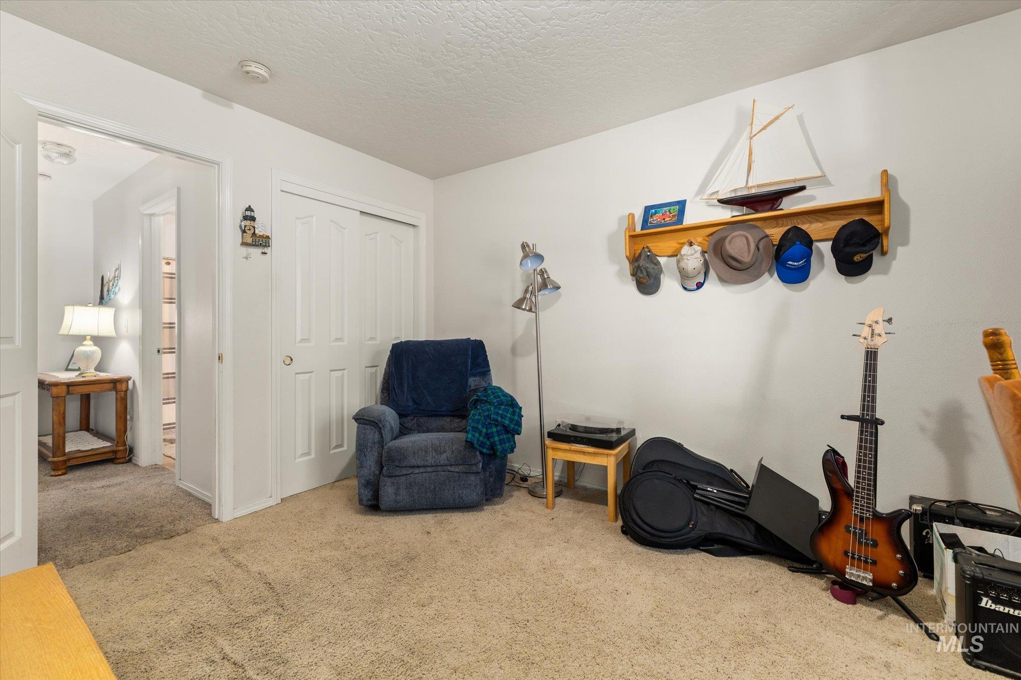 Living area with carpet flooring and a textured ceiling
