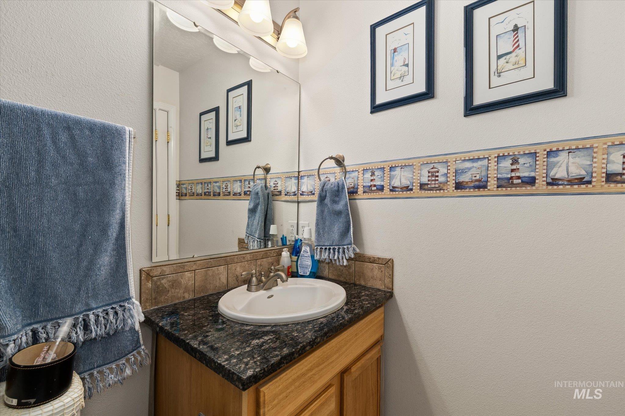 Bathroom featuring a textured wall and vanity
