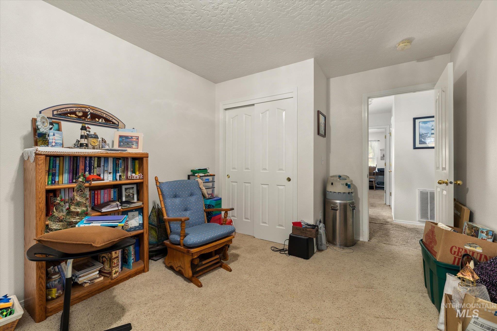 Sitting room with light carpet and a textured ceiling