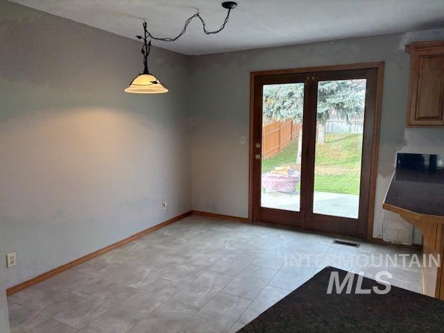 Unfurnished dining area featuring baseboards