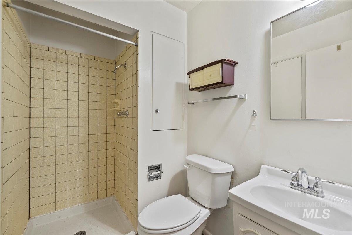 Full bath featuring a stall shower and vanity