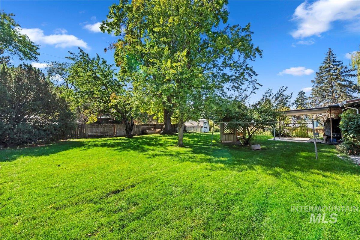 Fenced backyard featuring a storage shed and a patio area