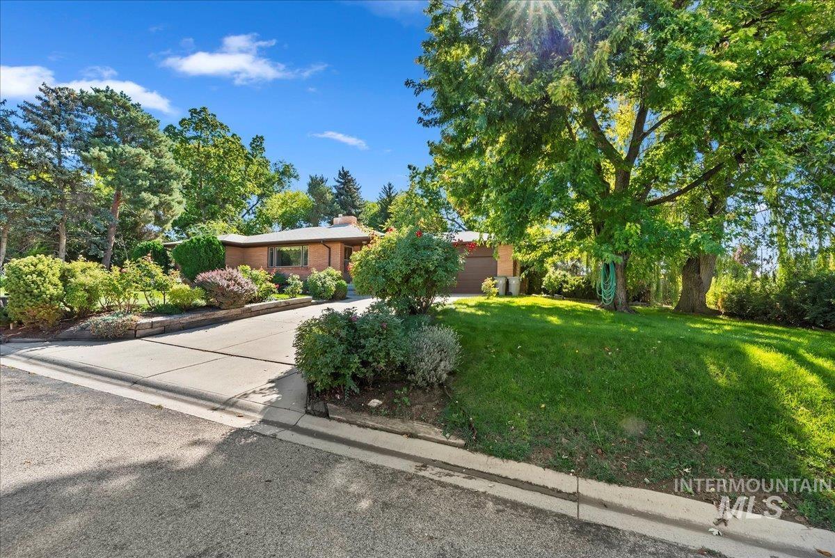 View of front of home featuring a front lawn, driveway, and a chimney