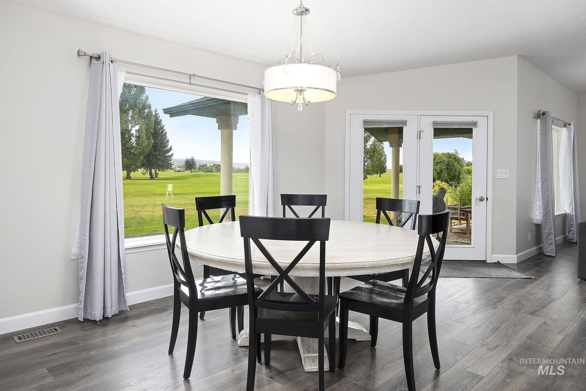 Dining area with french doors, healthy amount of natural light, and dark wood-style flooring