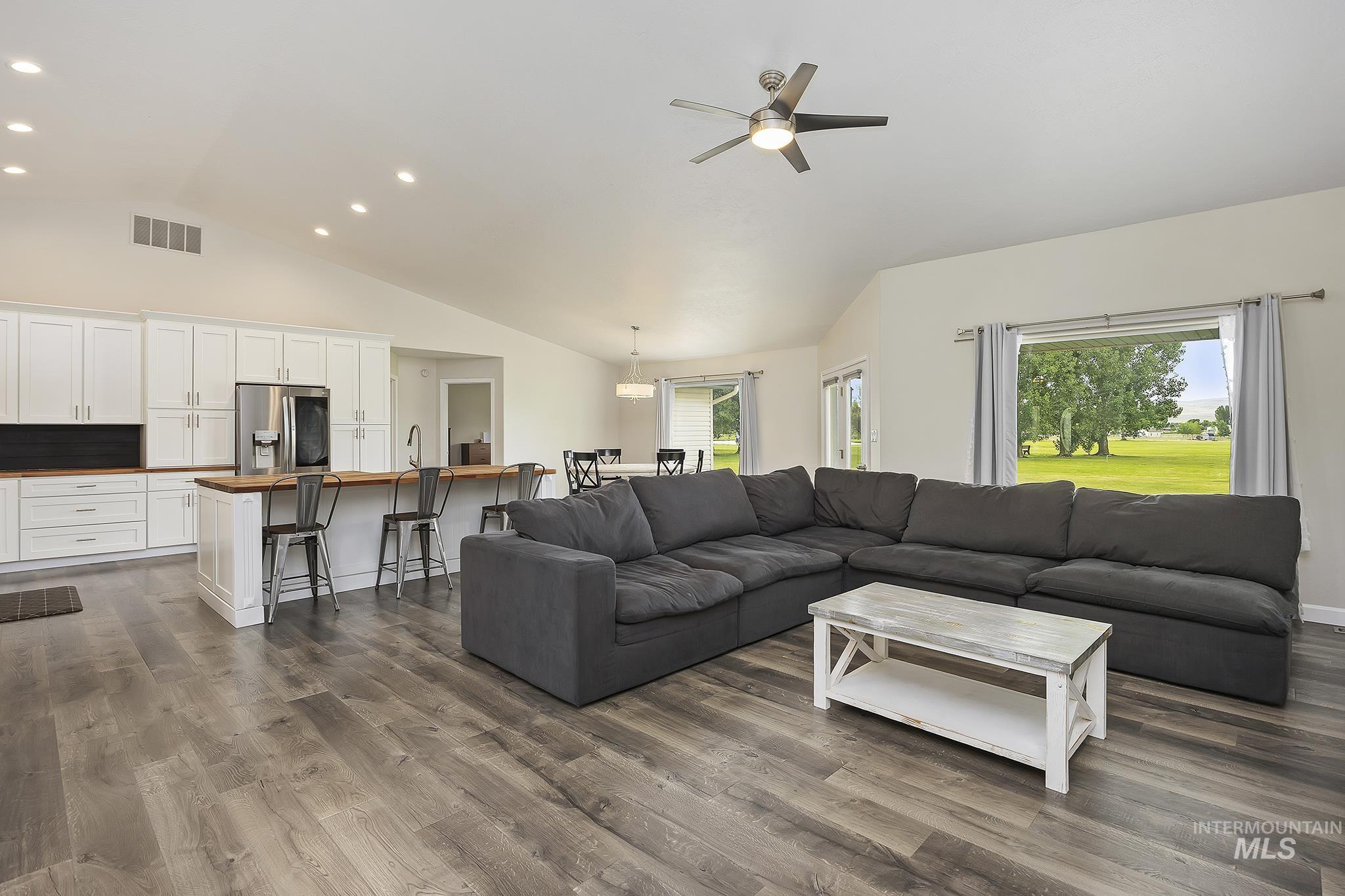 Living area featuring dark wood-style floors, recessed lighting, a ceiling fan, and high vaulted ceiling