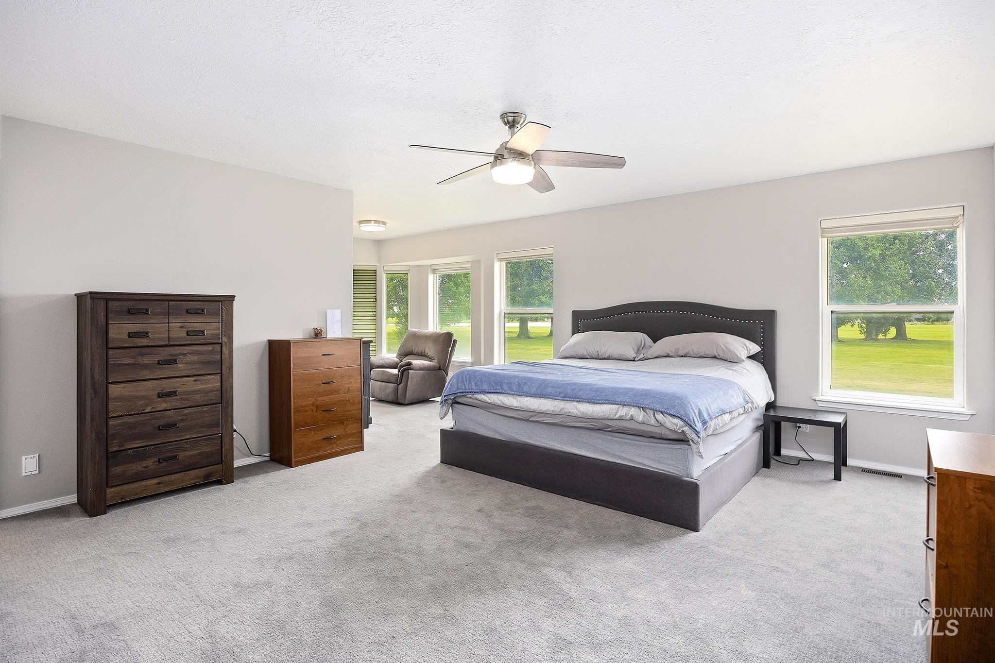 Bedroom featuring light colored carpet and ceiling fan
