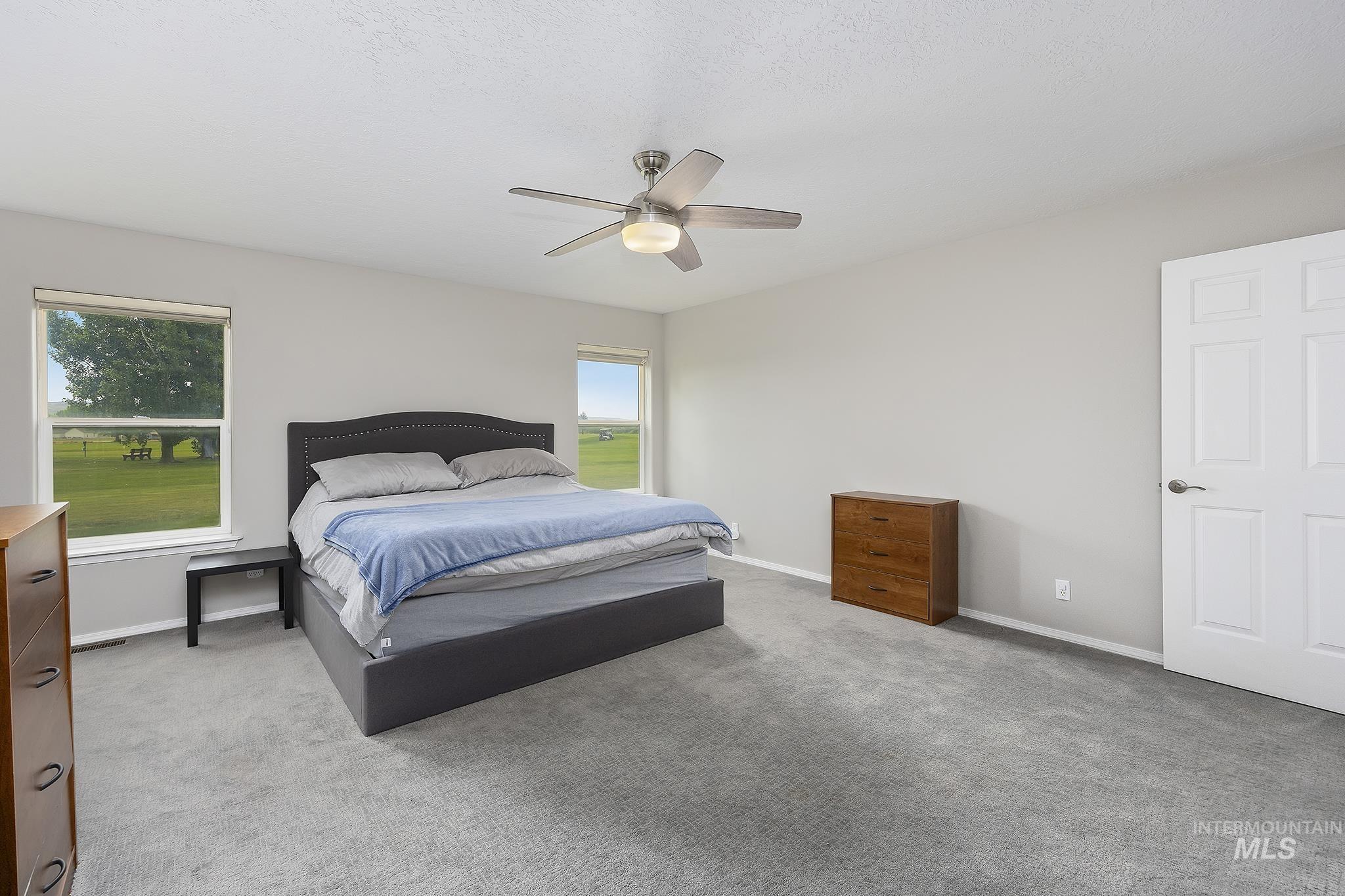 Bedroom featuring light colored carpet and ceiling fan