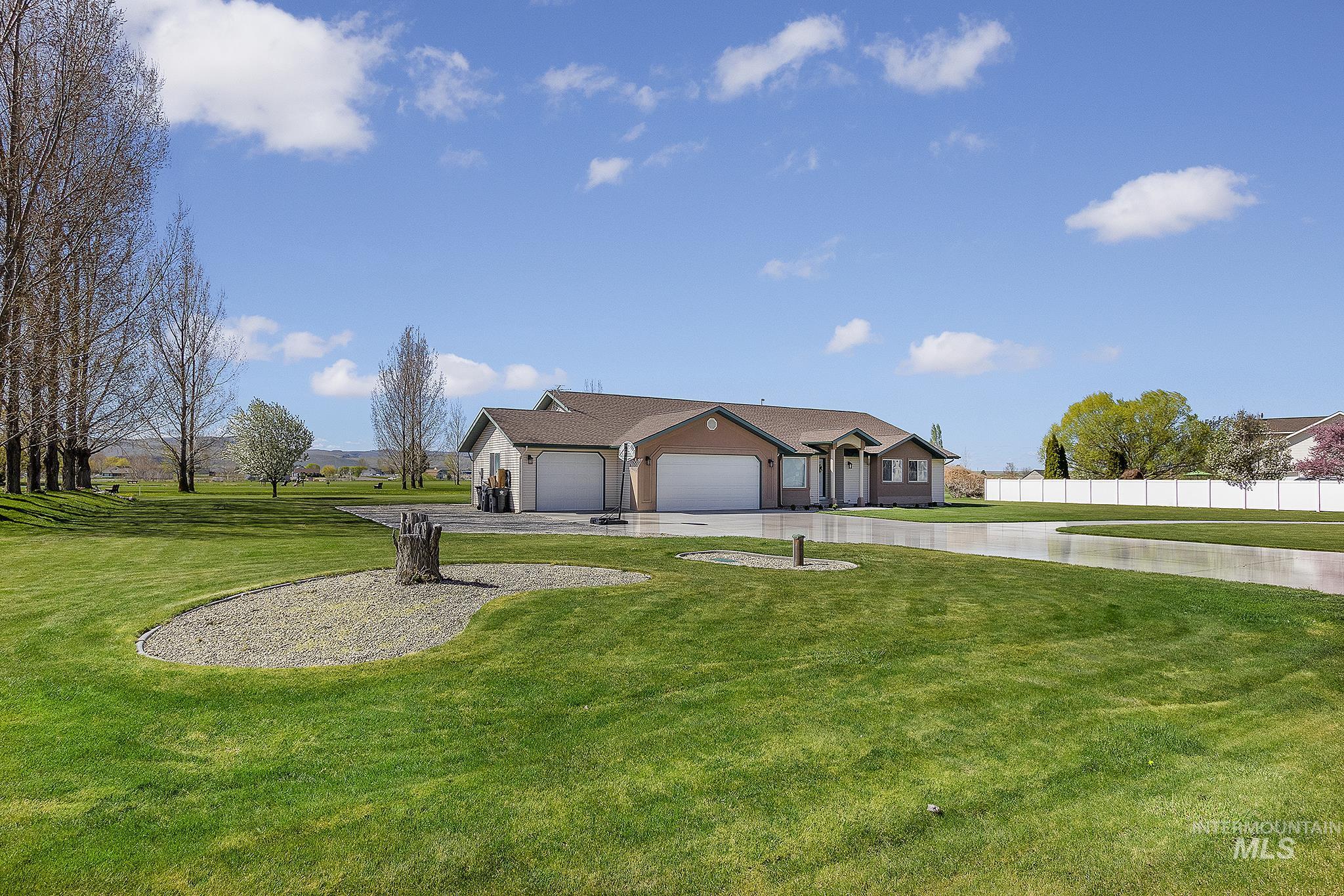 View of front of property with a front lawn, a garage, and driveway
