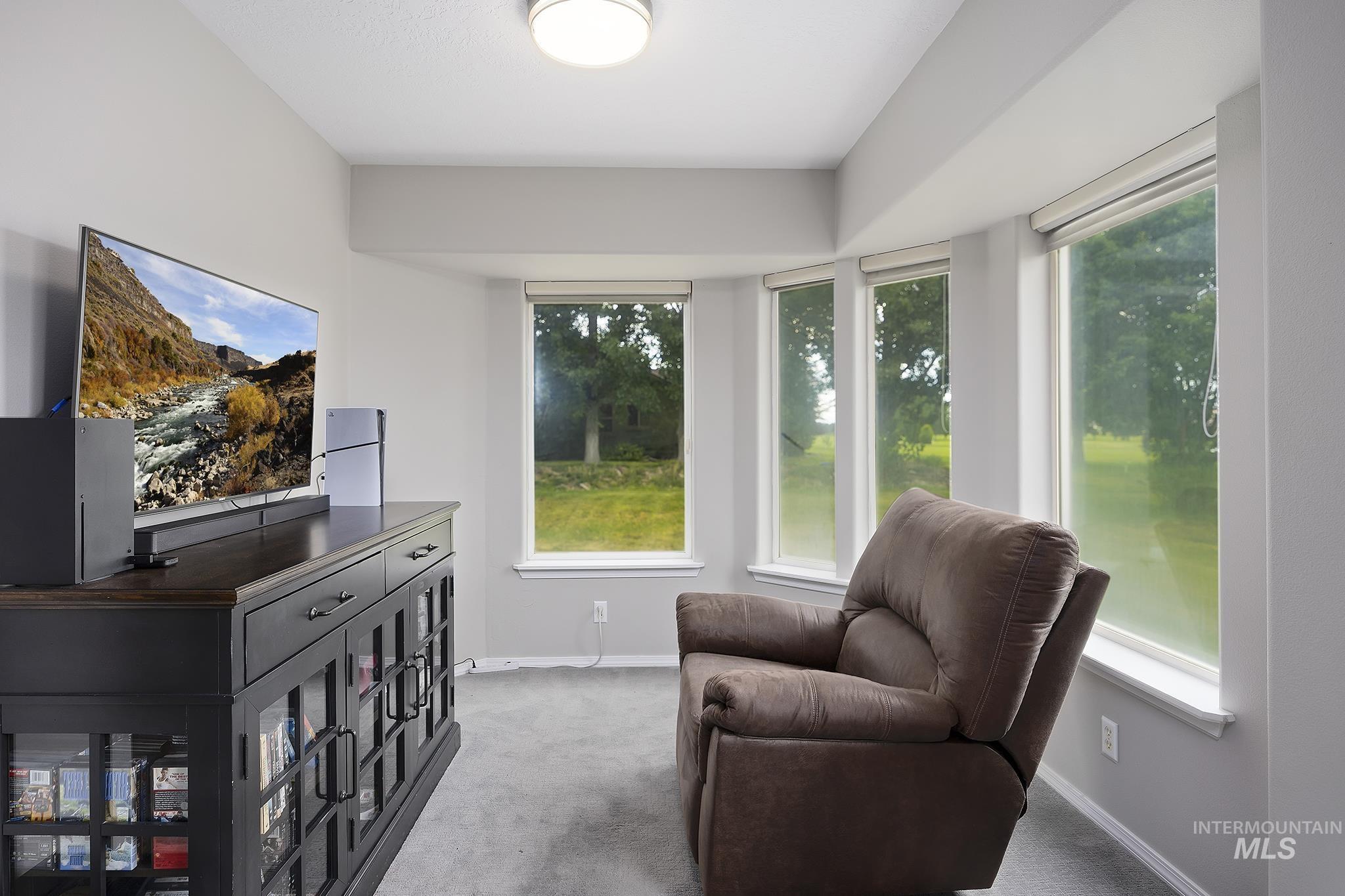 Living area with light carpet and baseboards