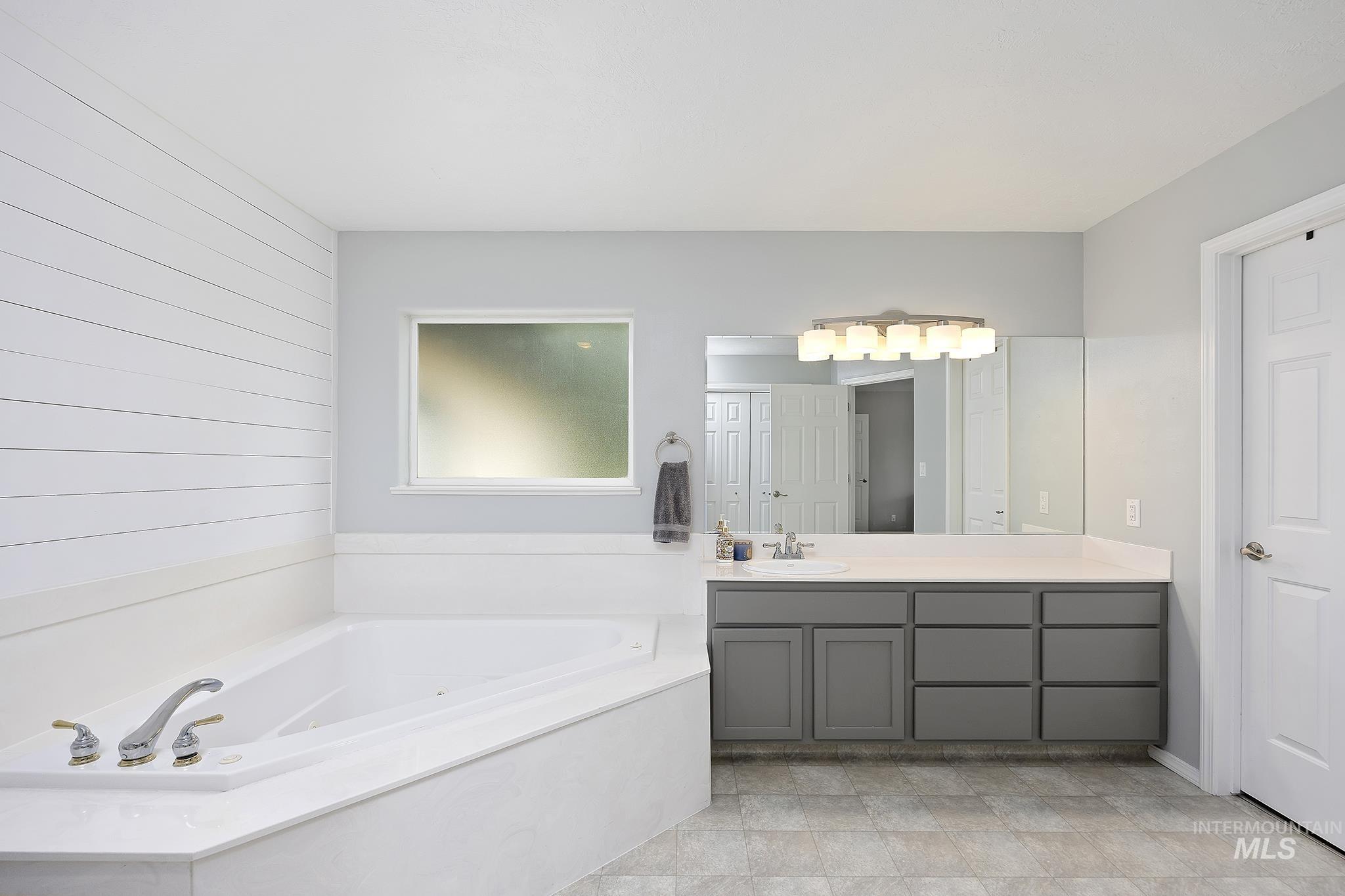 Full bathroom featuring vanity and a garden tub