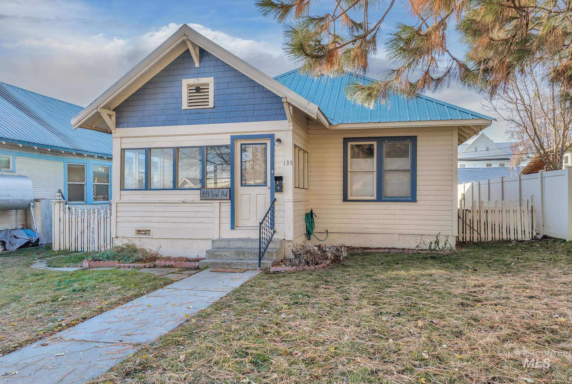 Bungalow-style house with a metal roof and entry steps