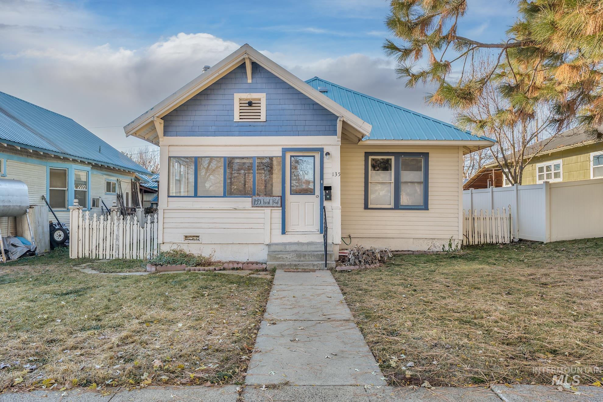 Bungalow featuring a metal roof and a sunroom