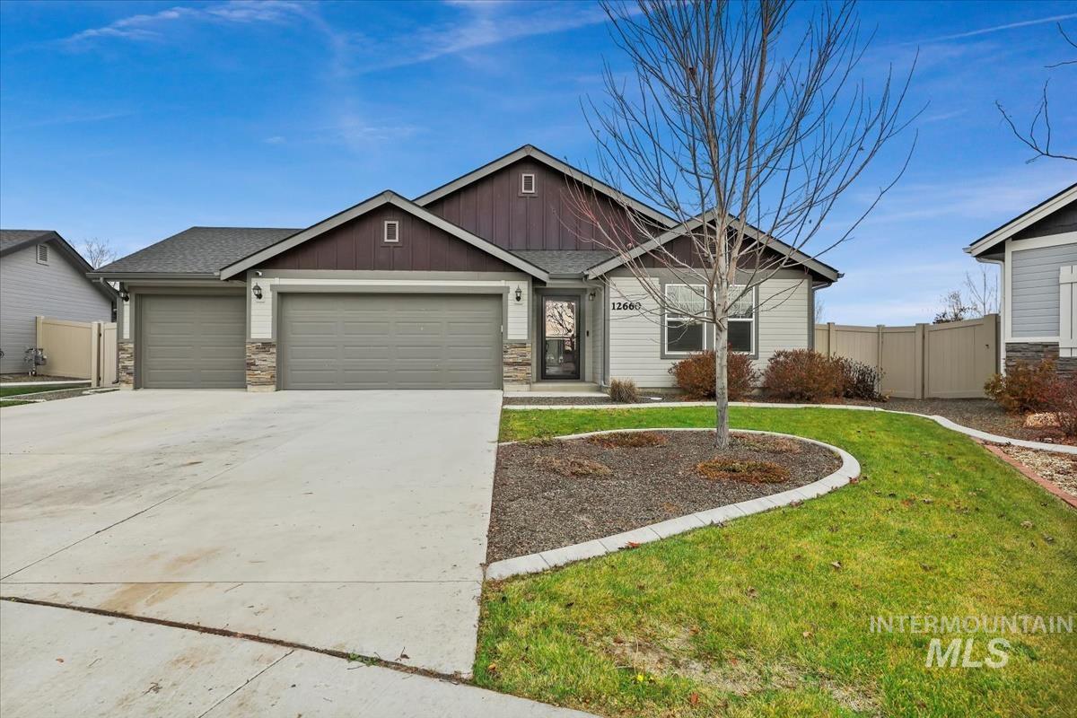 Craftsman house featuring board and batten siding, stone siding, a garage, and concrete driveway