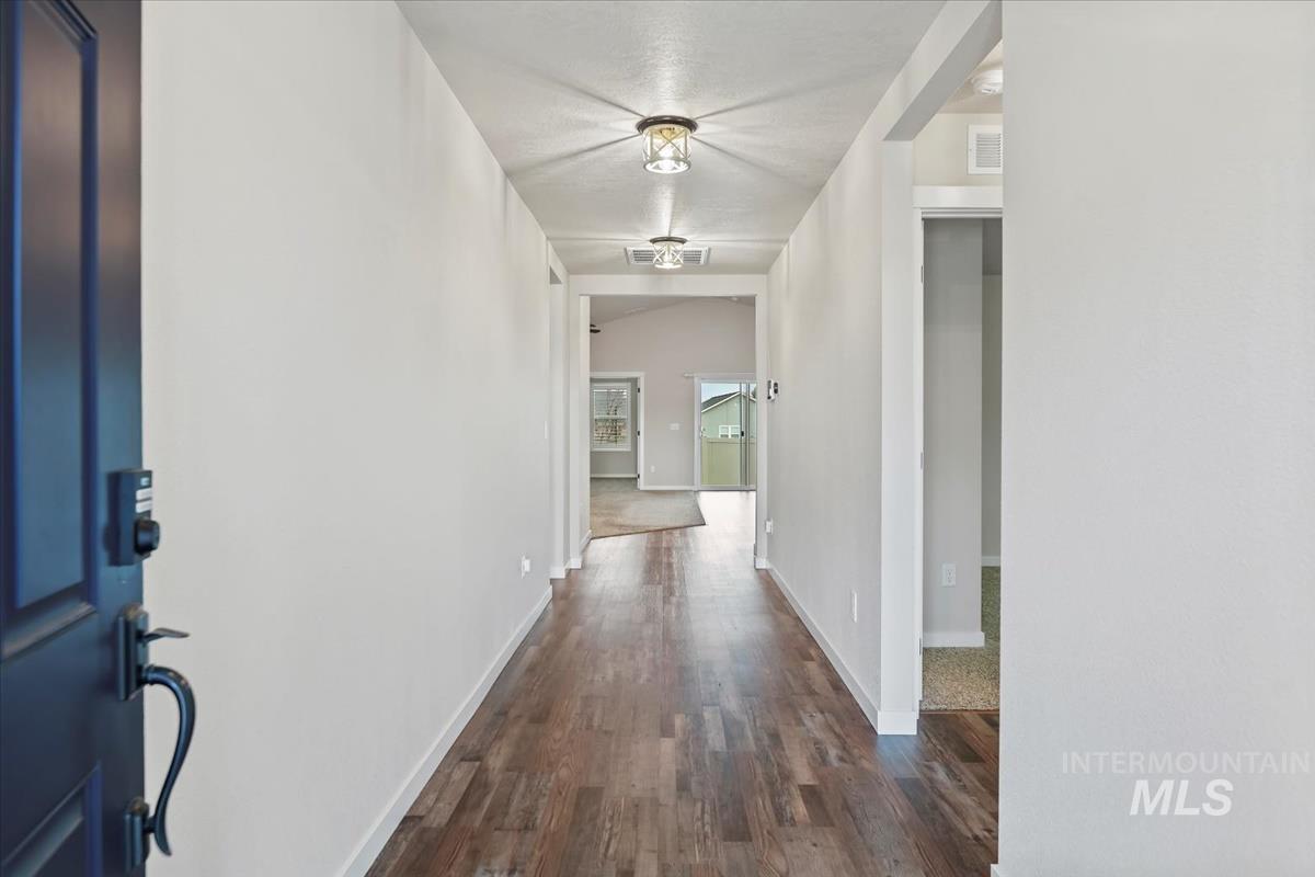 Hallway with dark wood finished floors and baseboards
