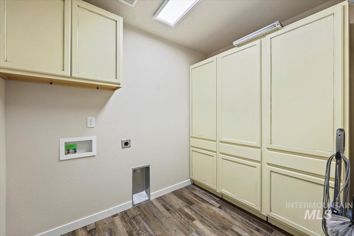 Laundry room featuring cabinet space, dark wood-style floors, hookup for a washing machine, and electric dryer hookup