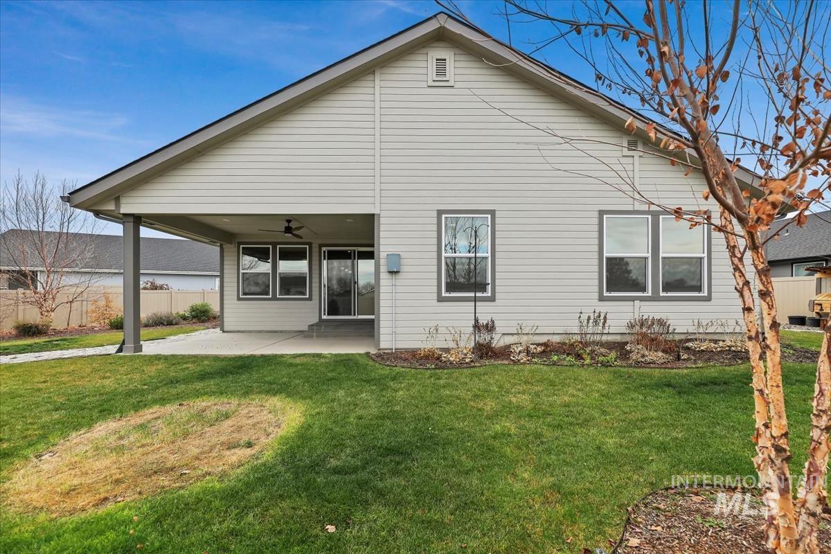 Rear view of property with a ceiling fan and a patio area