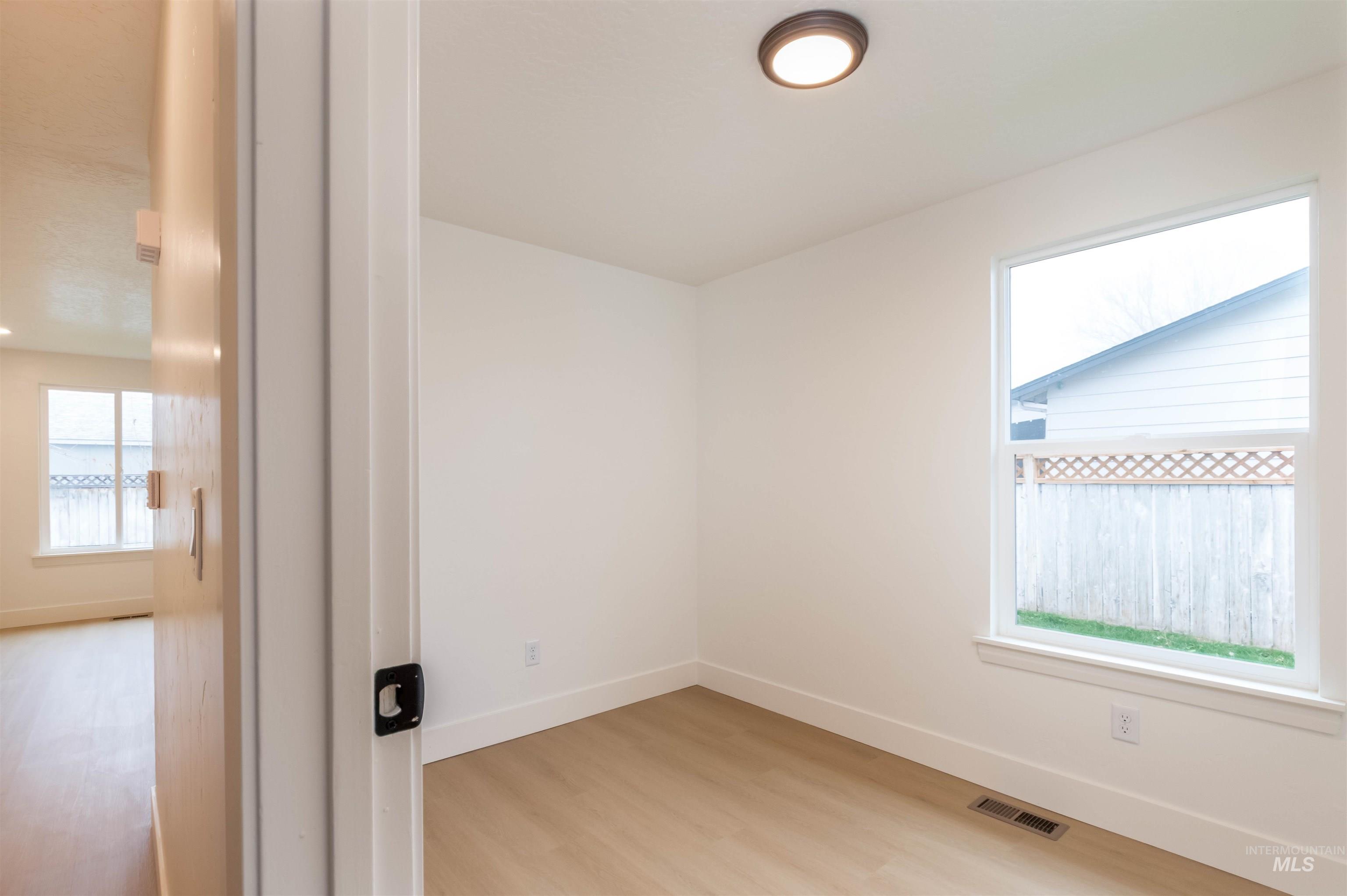 Spare room with baseboards and light wood-style flooring