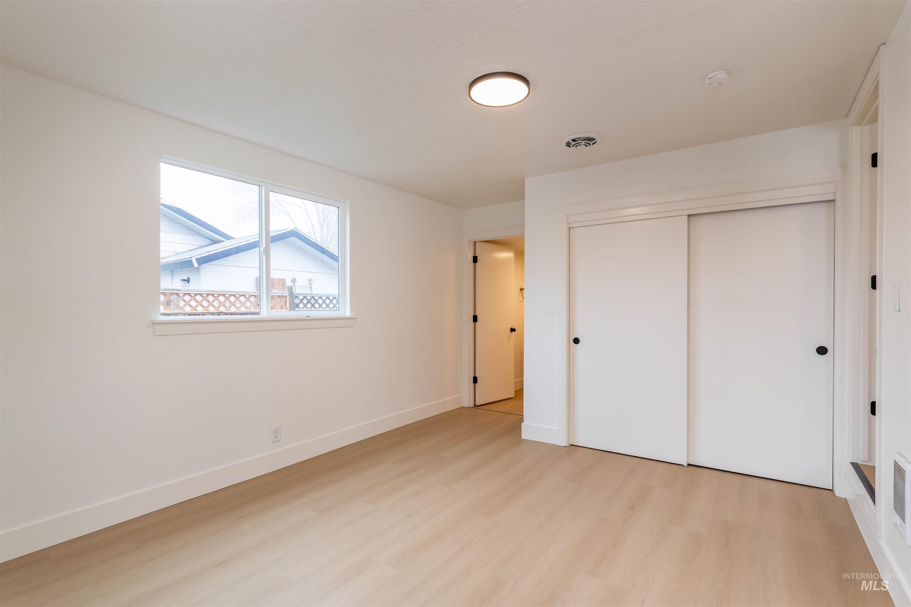 Unfurnished bedroom with a closet and light wood-style flooring