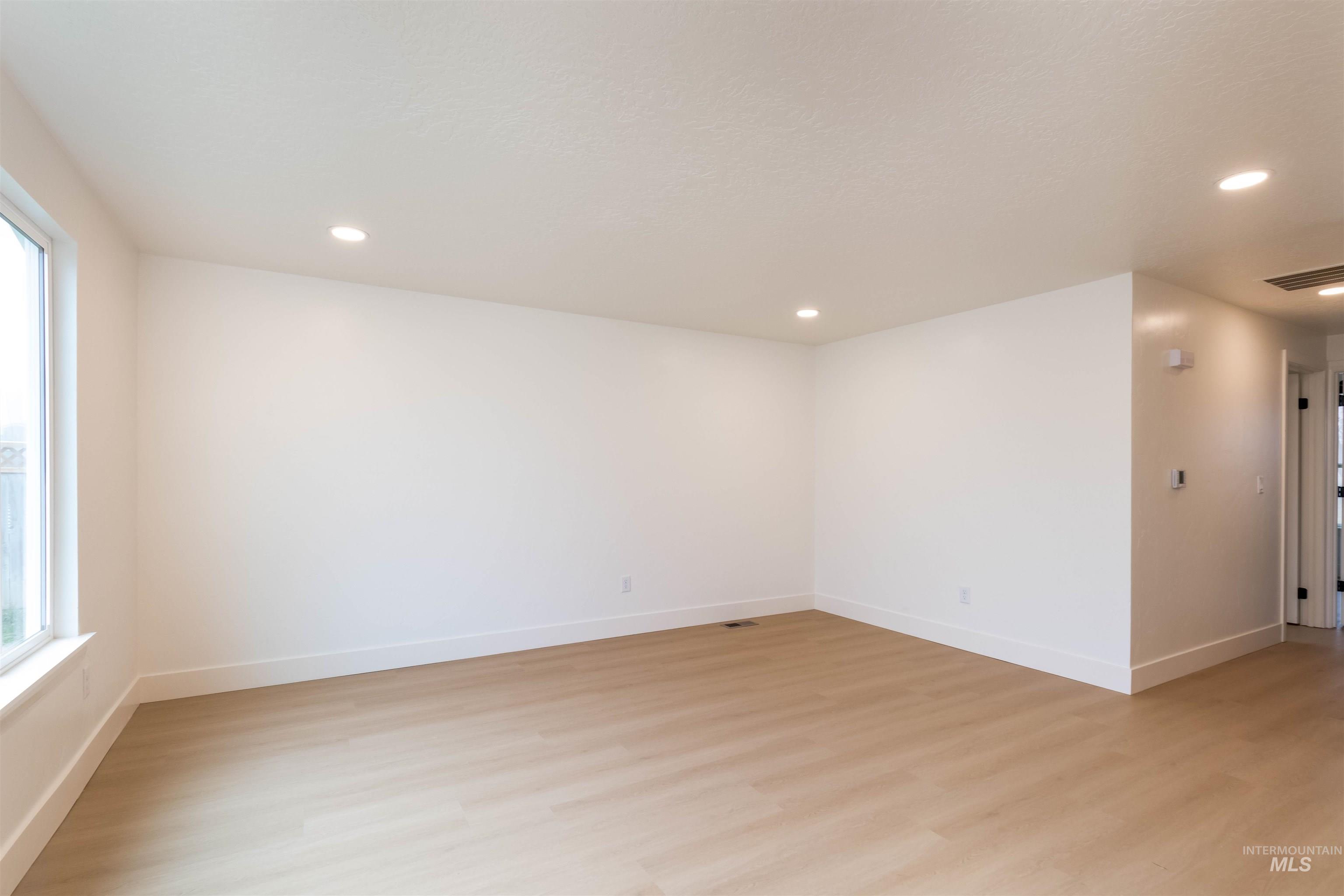 Spare room with light wood-style flooring and recessed lighting