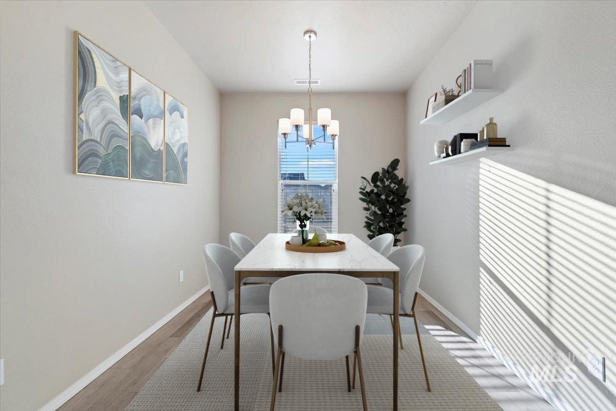 Dining room with wood finished floors and a chandelier