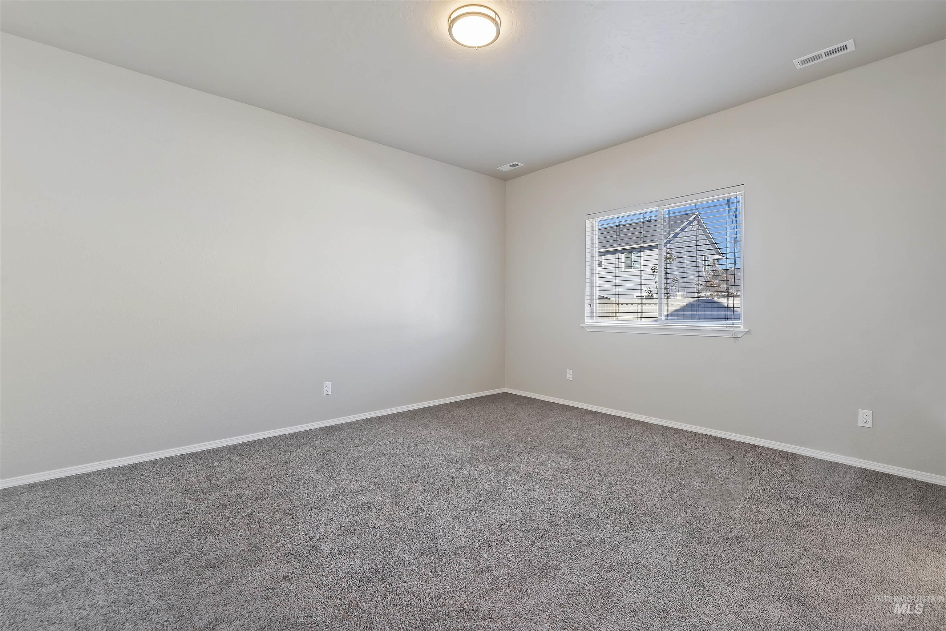 Carpeted spare room with baseboards