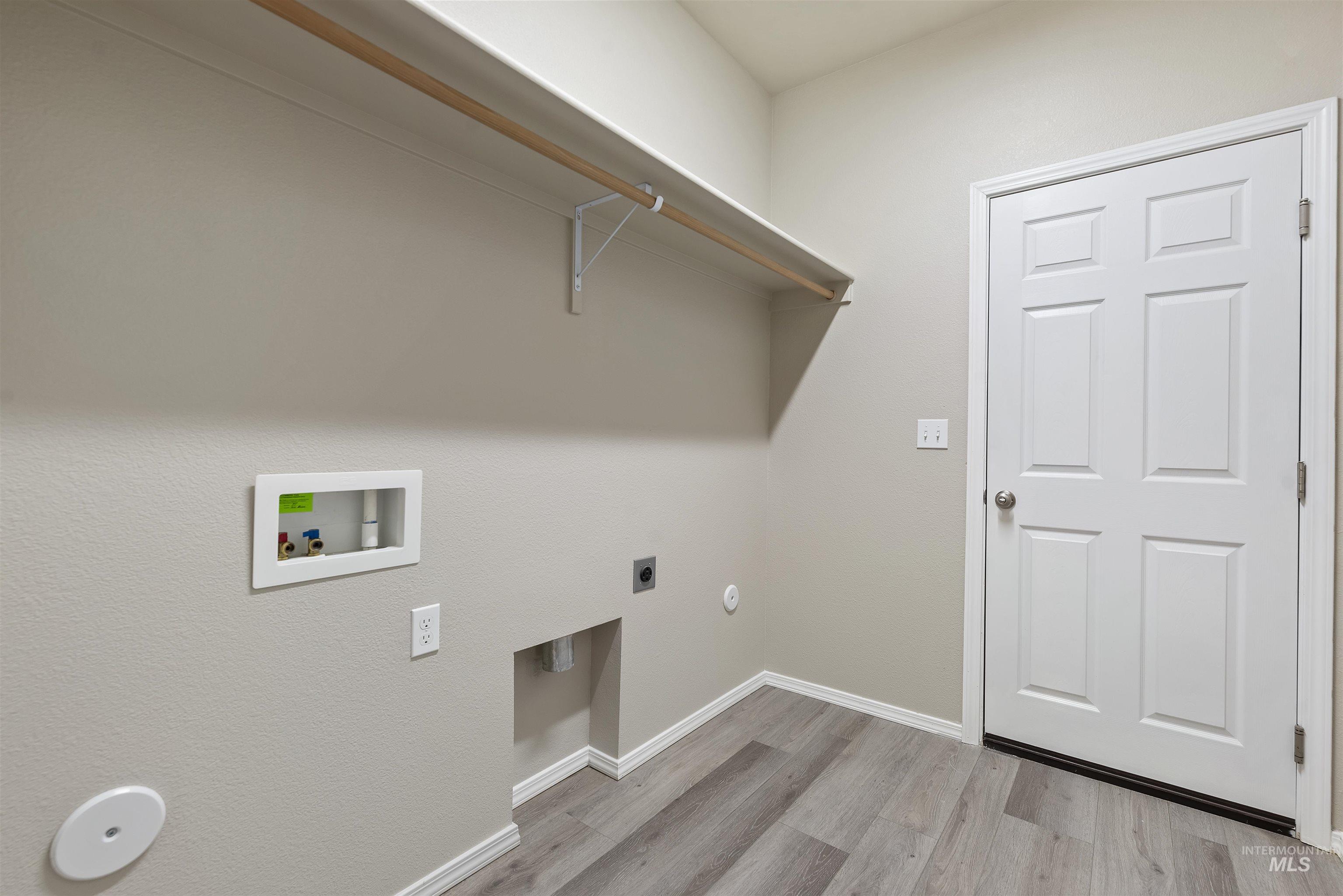 Washroom featuring hookup for a gas dryer, washer hookup, electric dryer hookup, and light wood finished floors