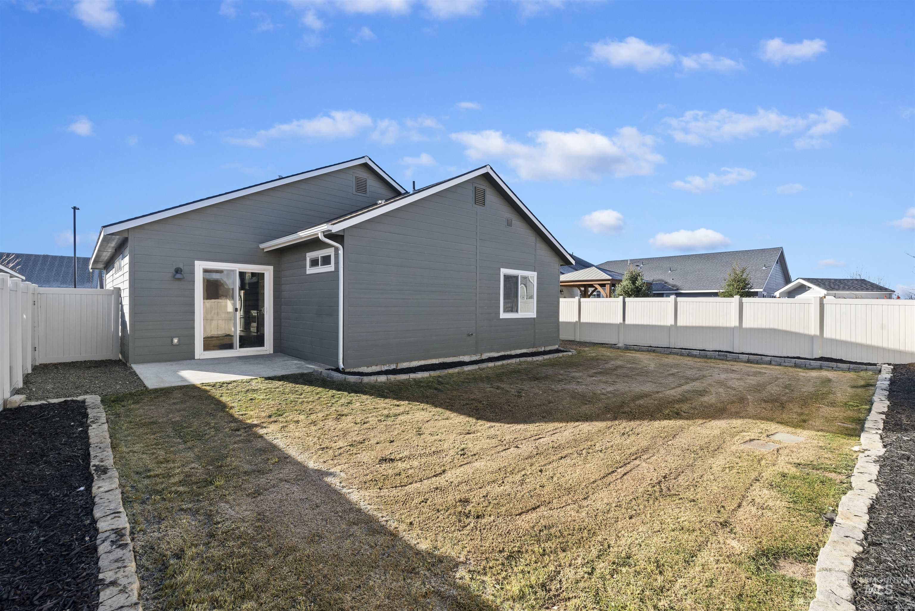 Back of house with a fenced backyard and a patio area