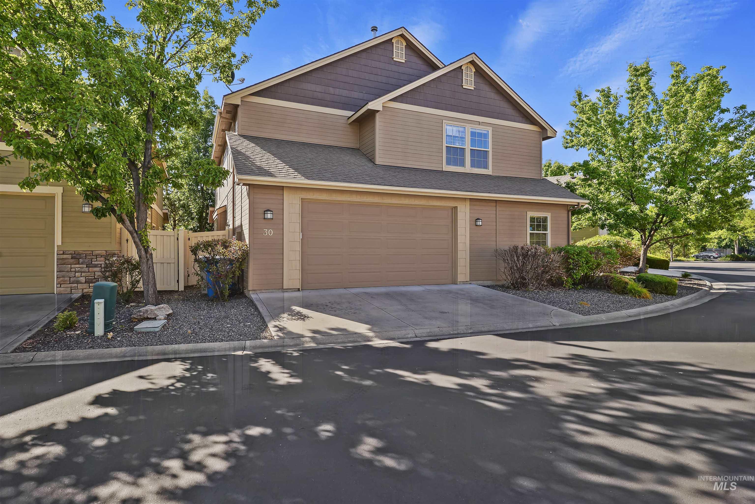 View of front facade featuring concrete driveway, a shingled roof, and a garage