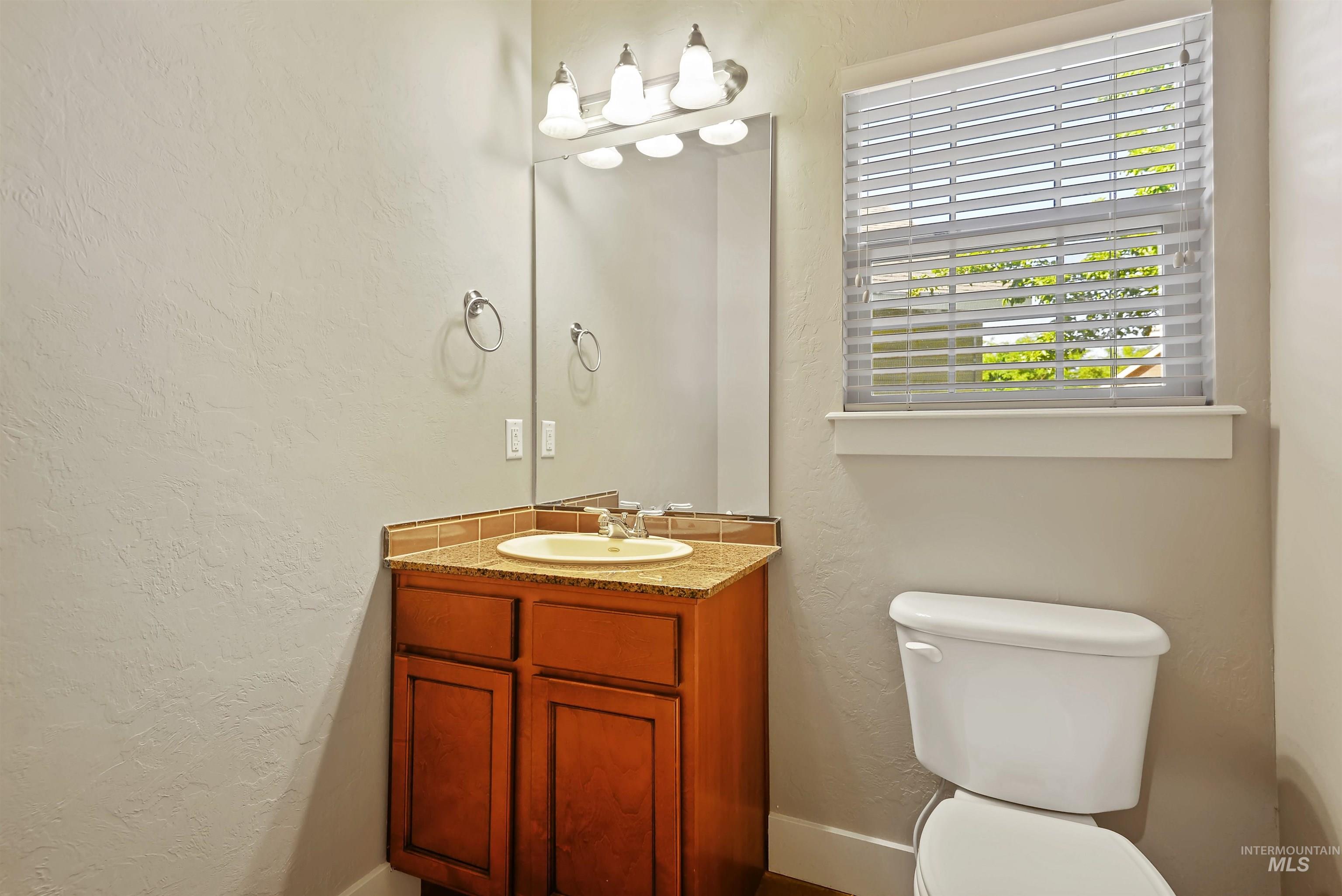 Bathroom with a textured wall and vanity