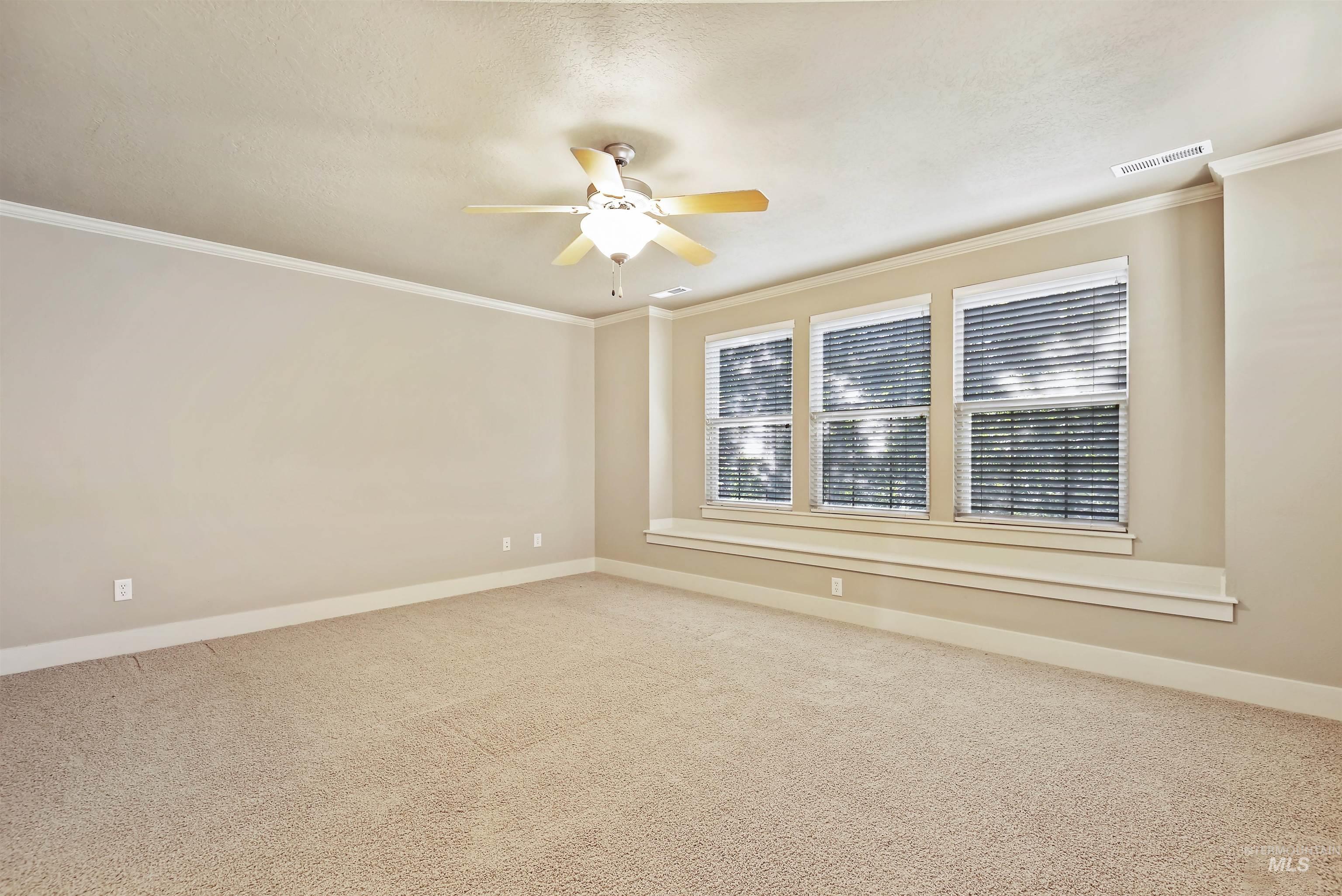 Unfurnished room featuring ornamental molding, carpet floors, and ceiling fan