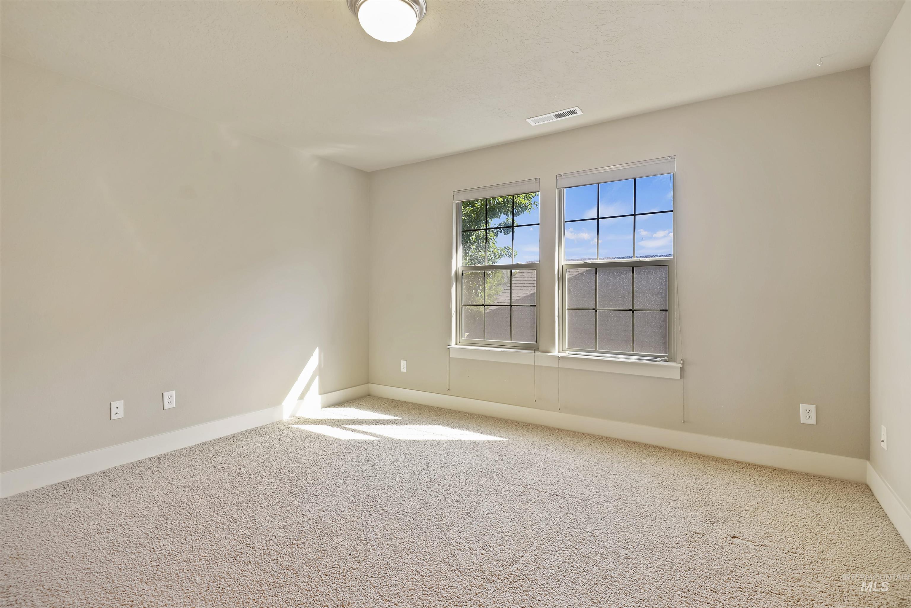 Carpeted empty room featuring baseboards