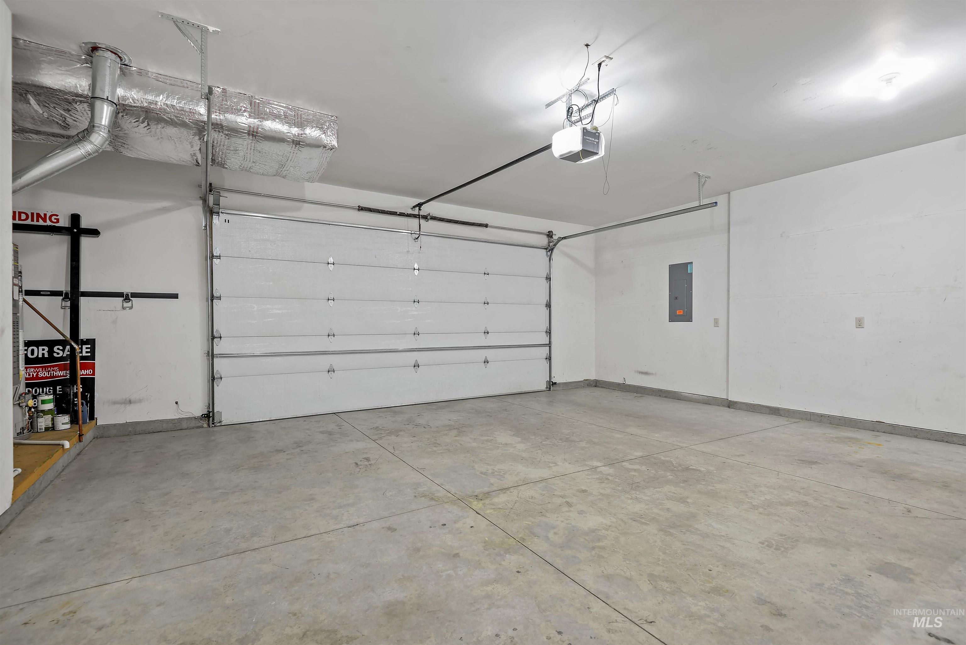 Garage featuring electric panel and a garage door opener