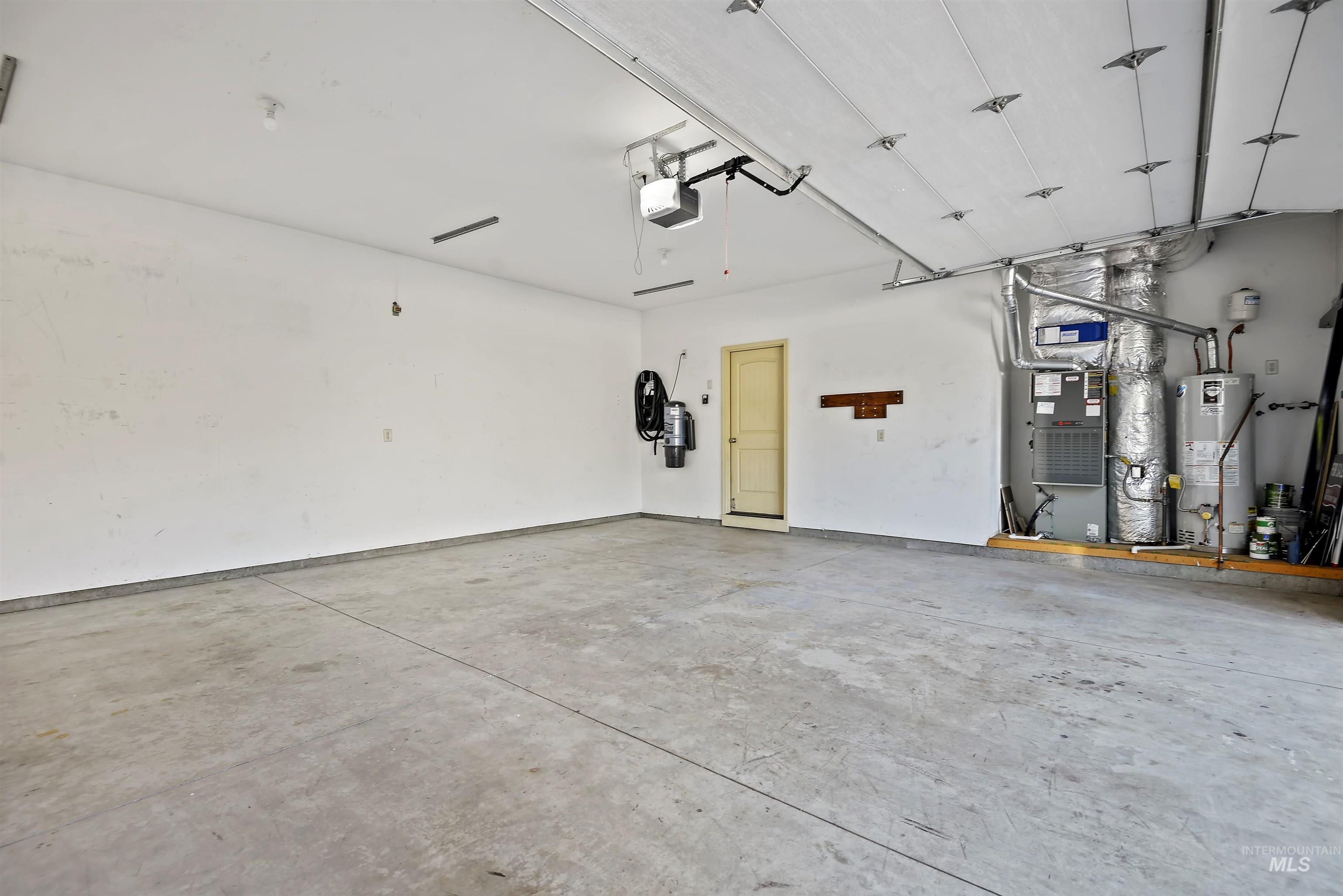 Garage featuring gas water heater and a garage door opener