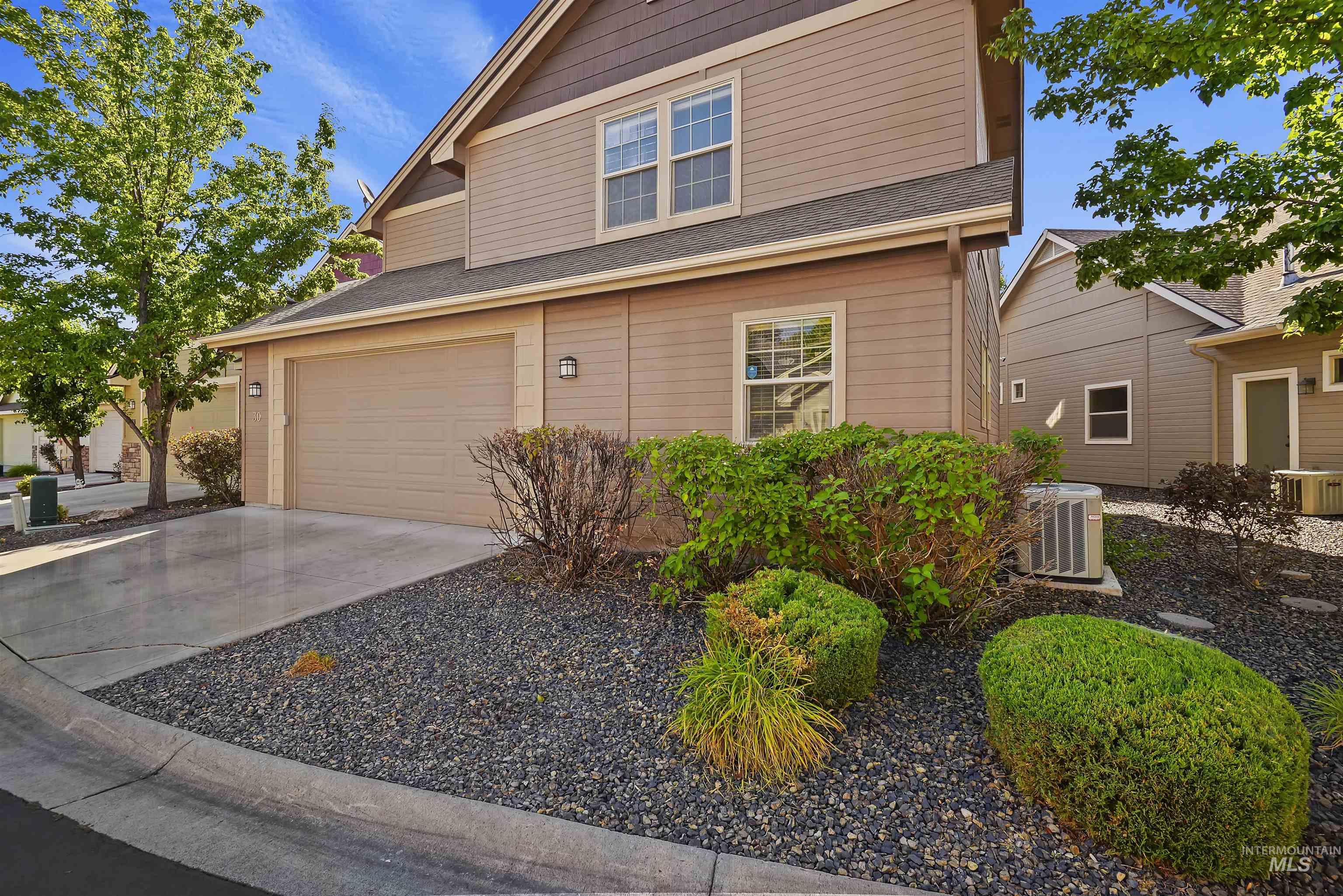 View of front of house featuring driveway, an attached garage, and roof with shingles