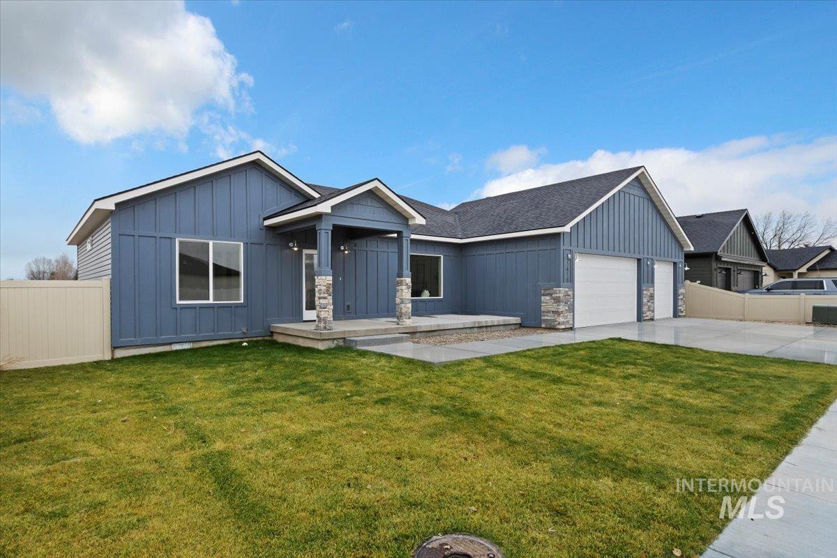 Craftsman-style house with board and batten siding, stone siding, a garage, and concrete driveway