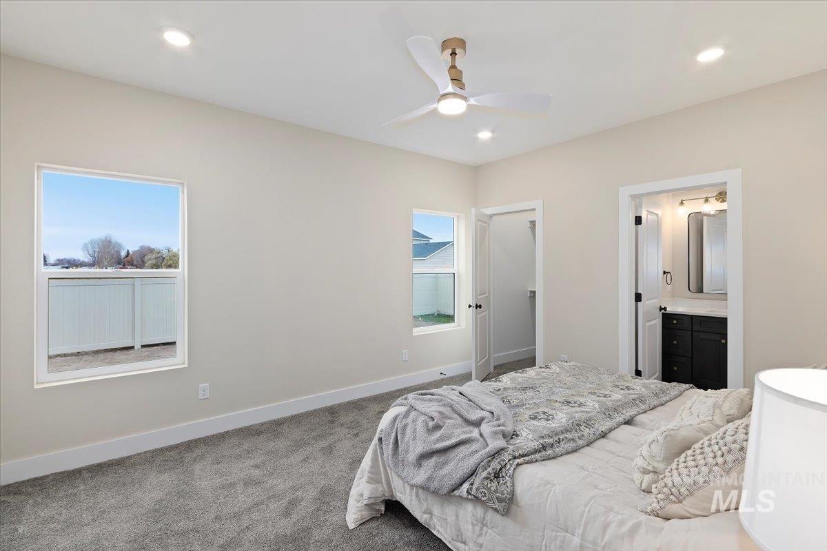 Carpeted bedroom with ceiling fan, connected bathroom, and recessed lighting