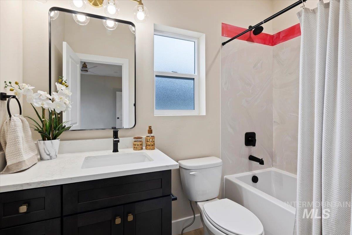 Full bath with shower / bath combination with curtain and vanity