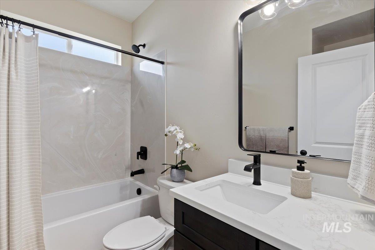 Full bathroom with shower / tub combo with curtain and vanity