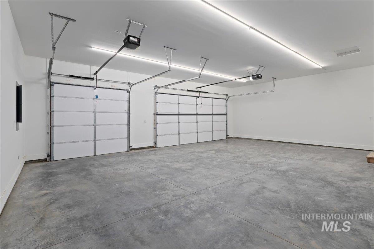 Garage featuring a garage door opener and electric panel