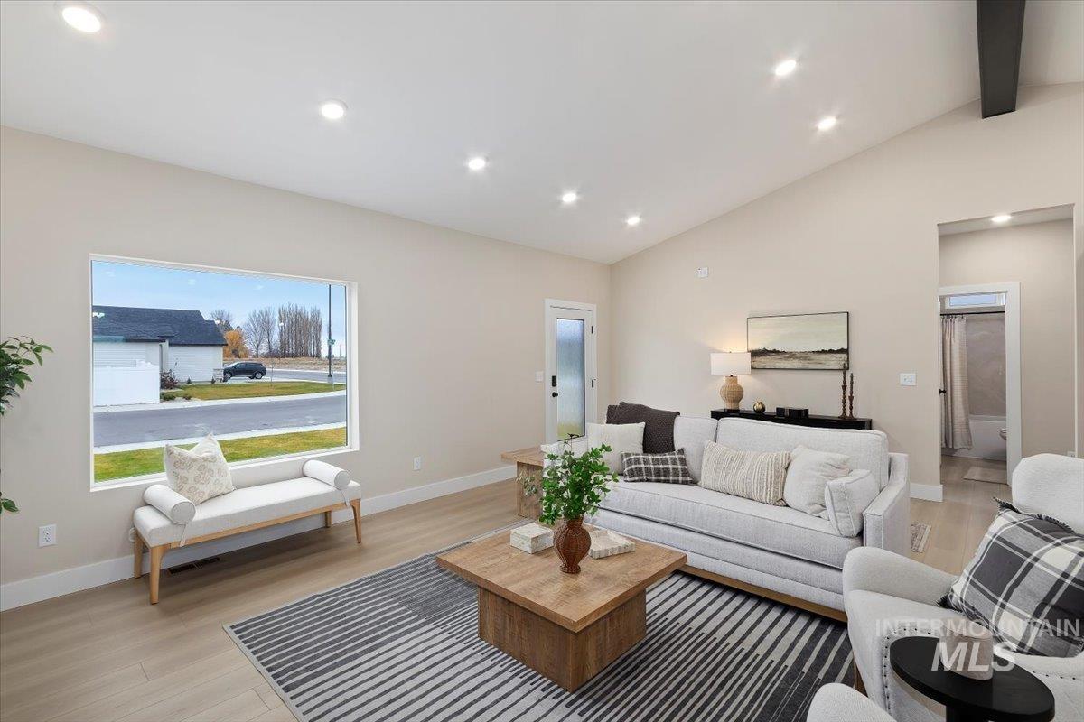 Living room featuring recessed lighting, light wood-style floors, beamed ceiling, and high vaulted ceiling