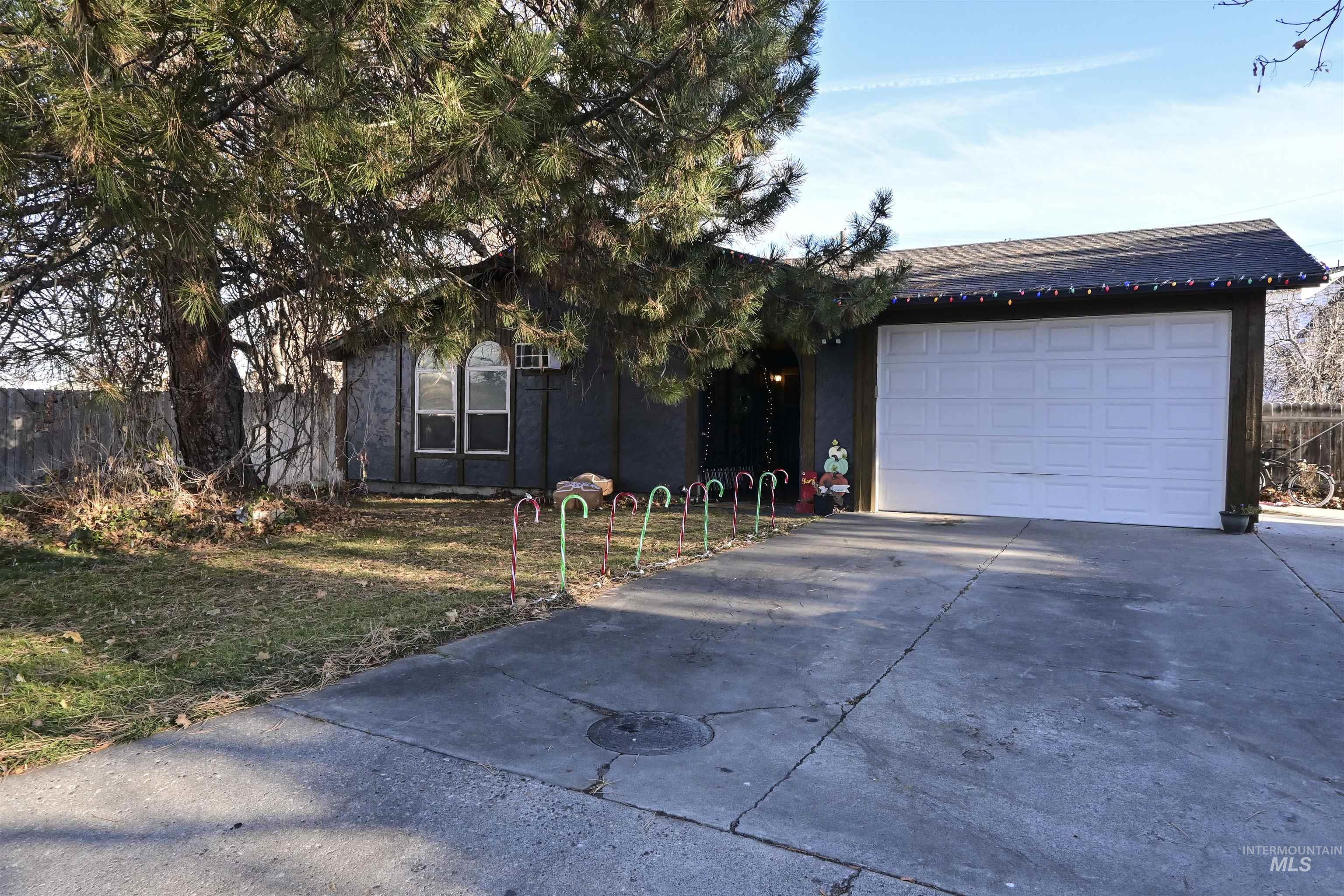 View of front of home featuring driveway, stucco siding, a shingled roof, and a garage