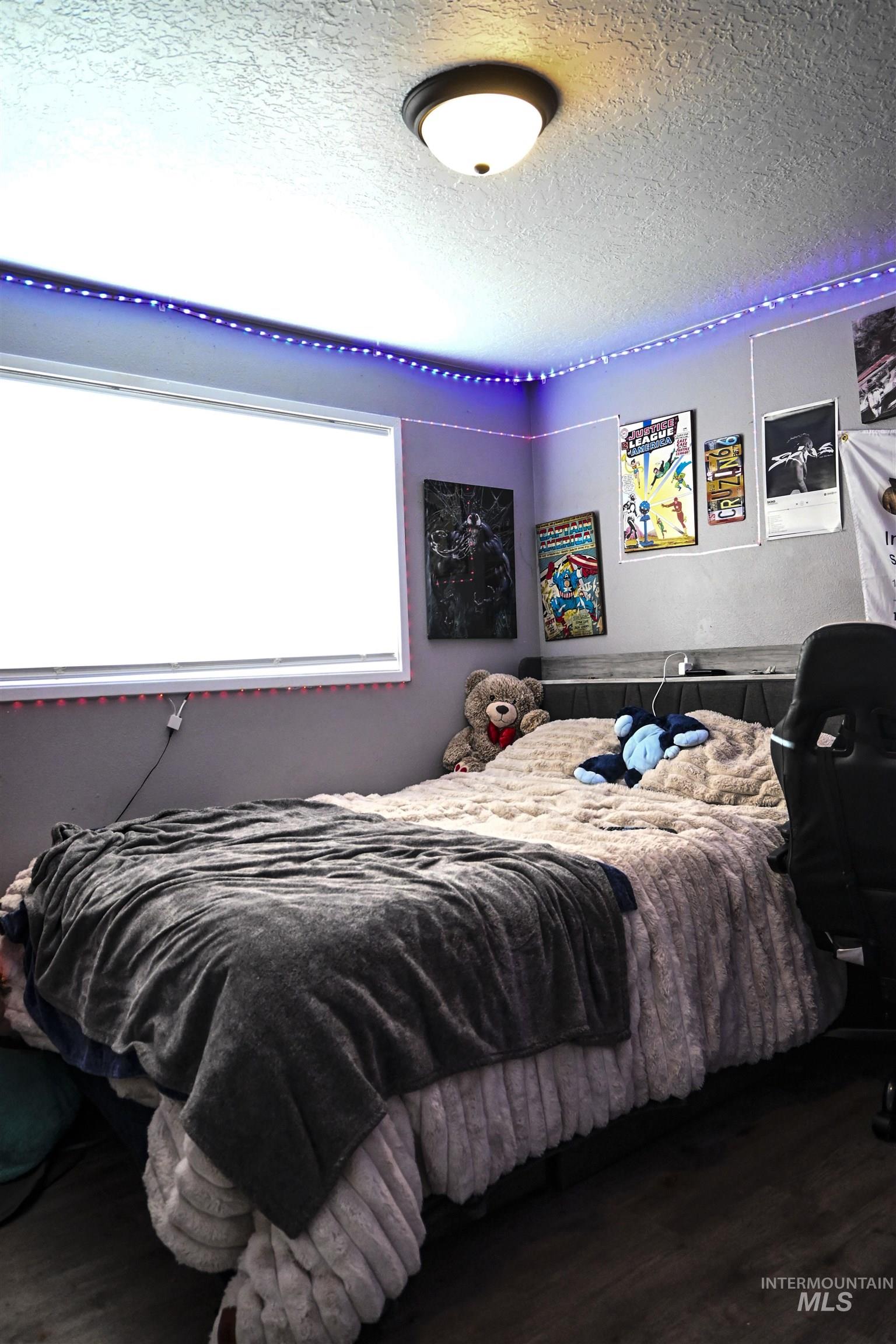 Bedroom with a textured ceiling and wood finished floors